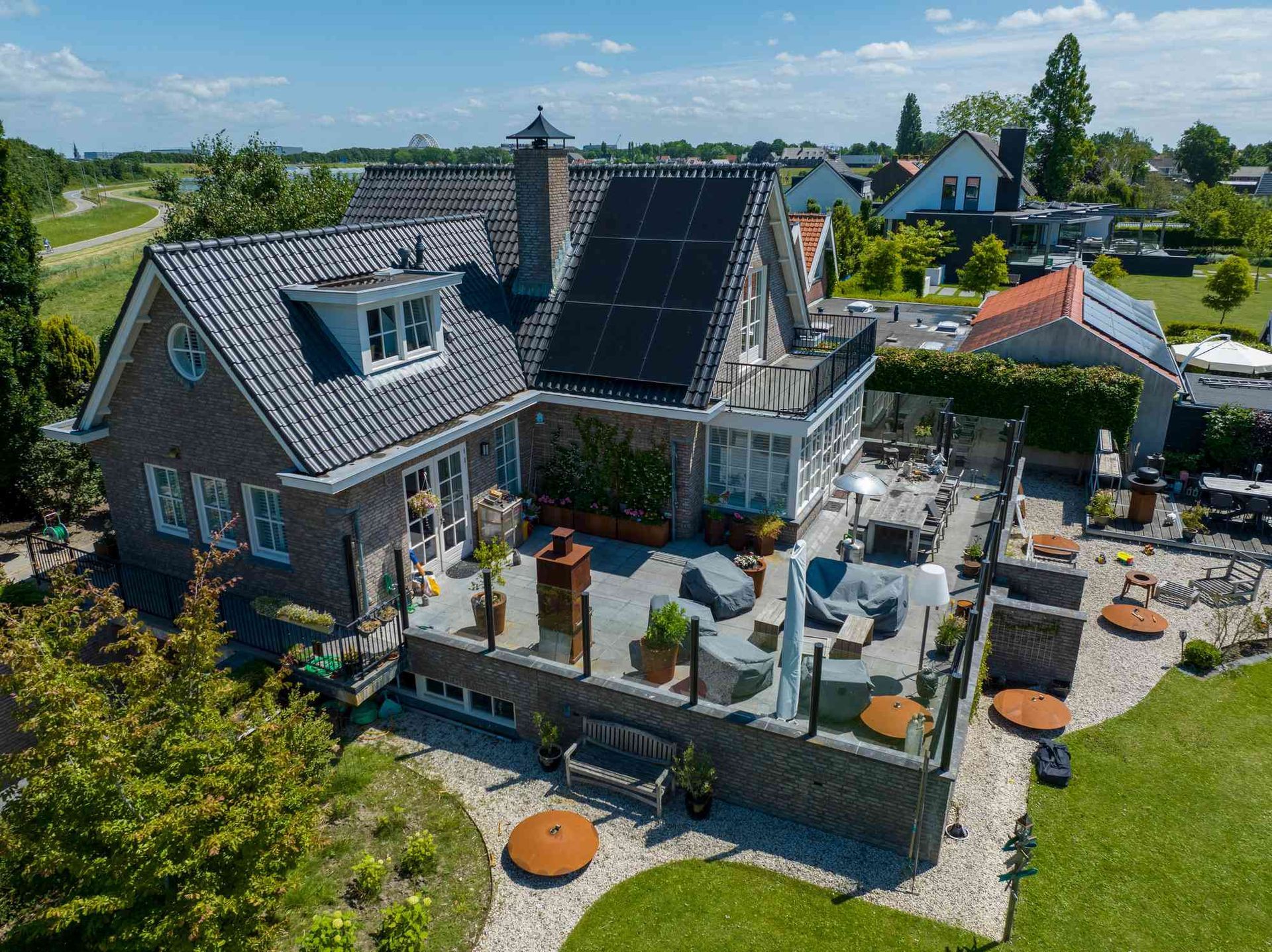 Een luchtfoto van een groot huis met zonnepanelen op het dak