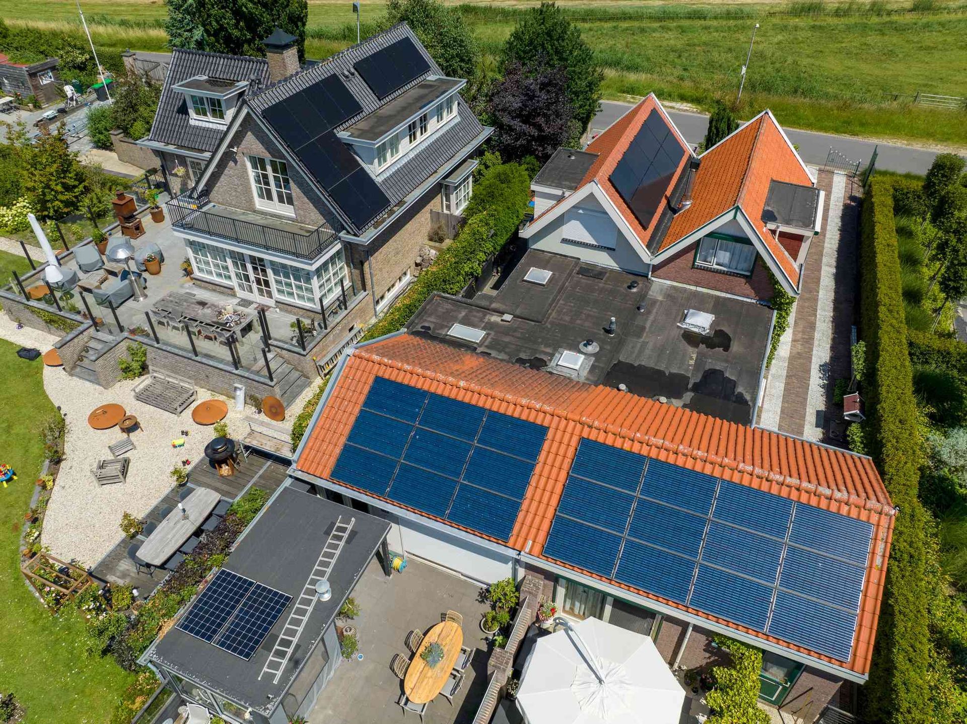 Een luchtfoto van een huis met zonnepanelen op het dak.