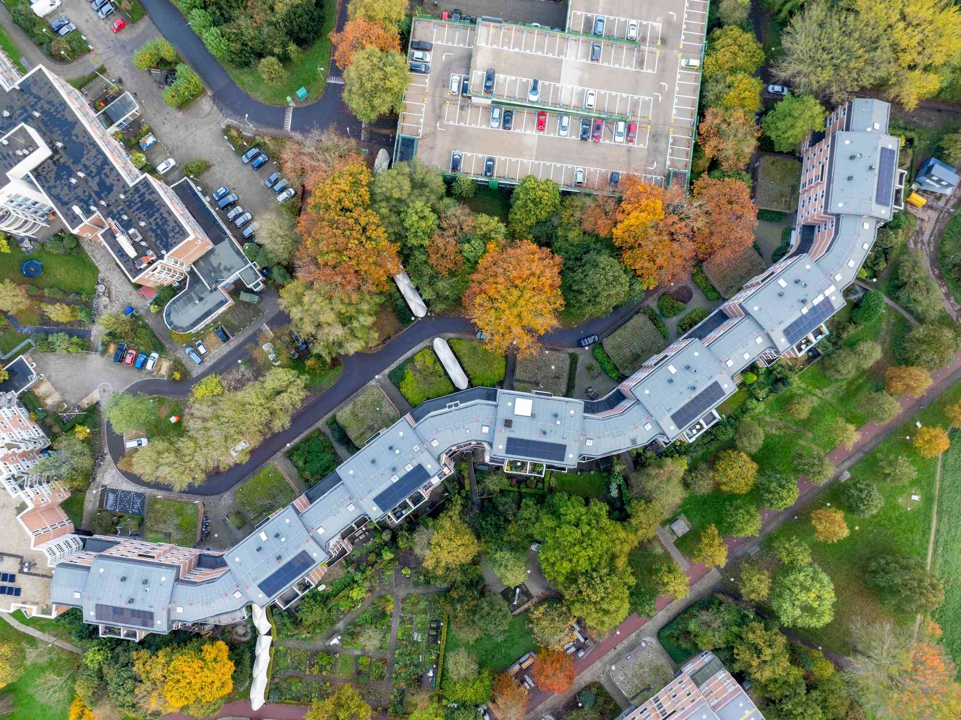 Een luchtfoto van een woonwijk met veel gebouwen en bomen.