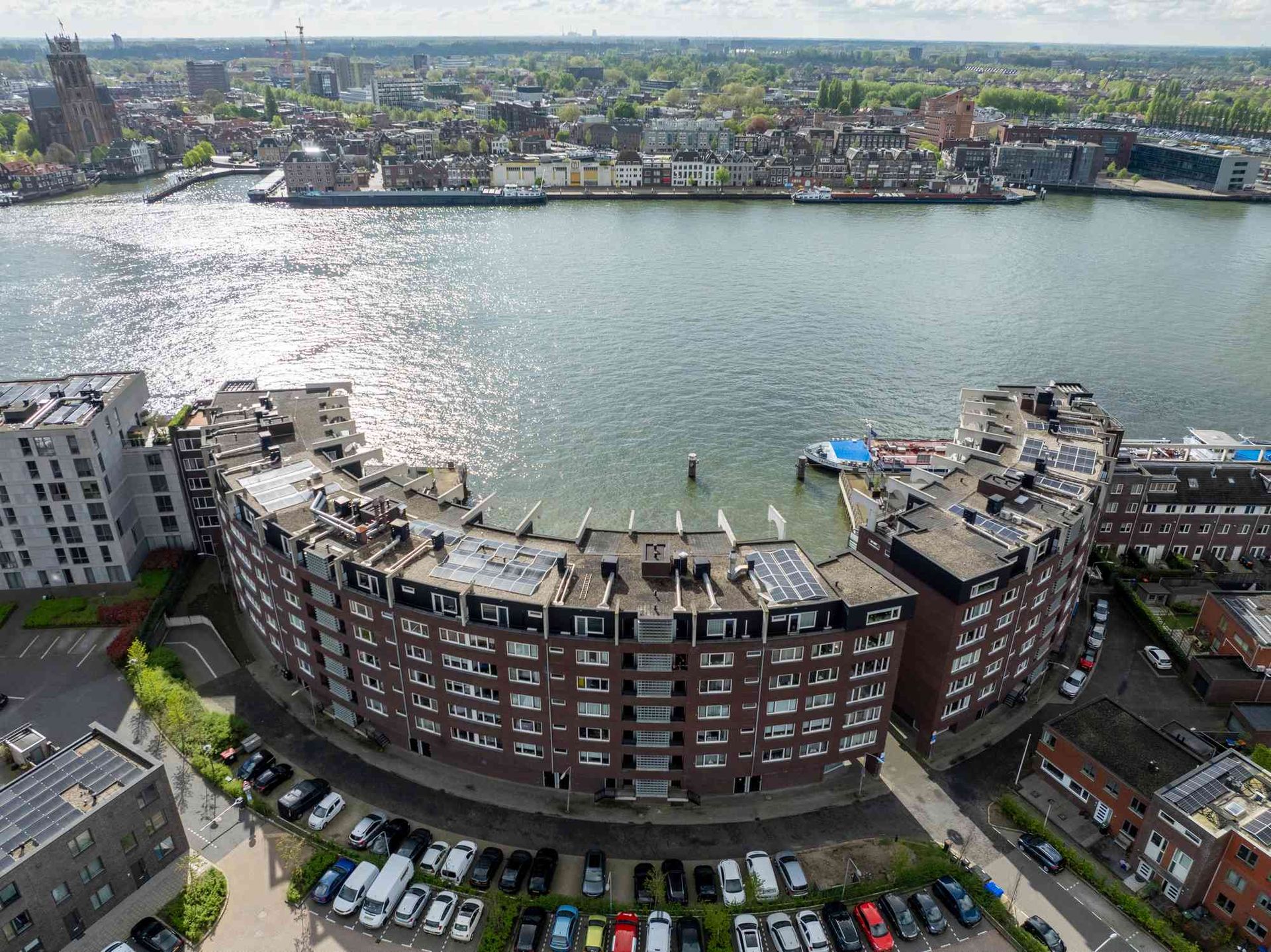 Een luchtfoto van een groot gebouw naast een waterpartij.