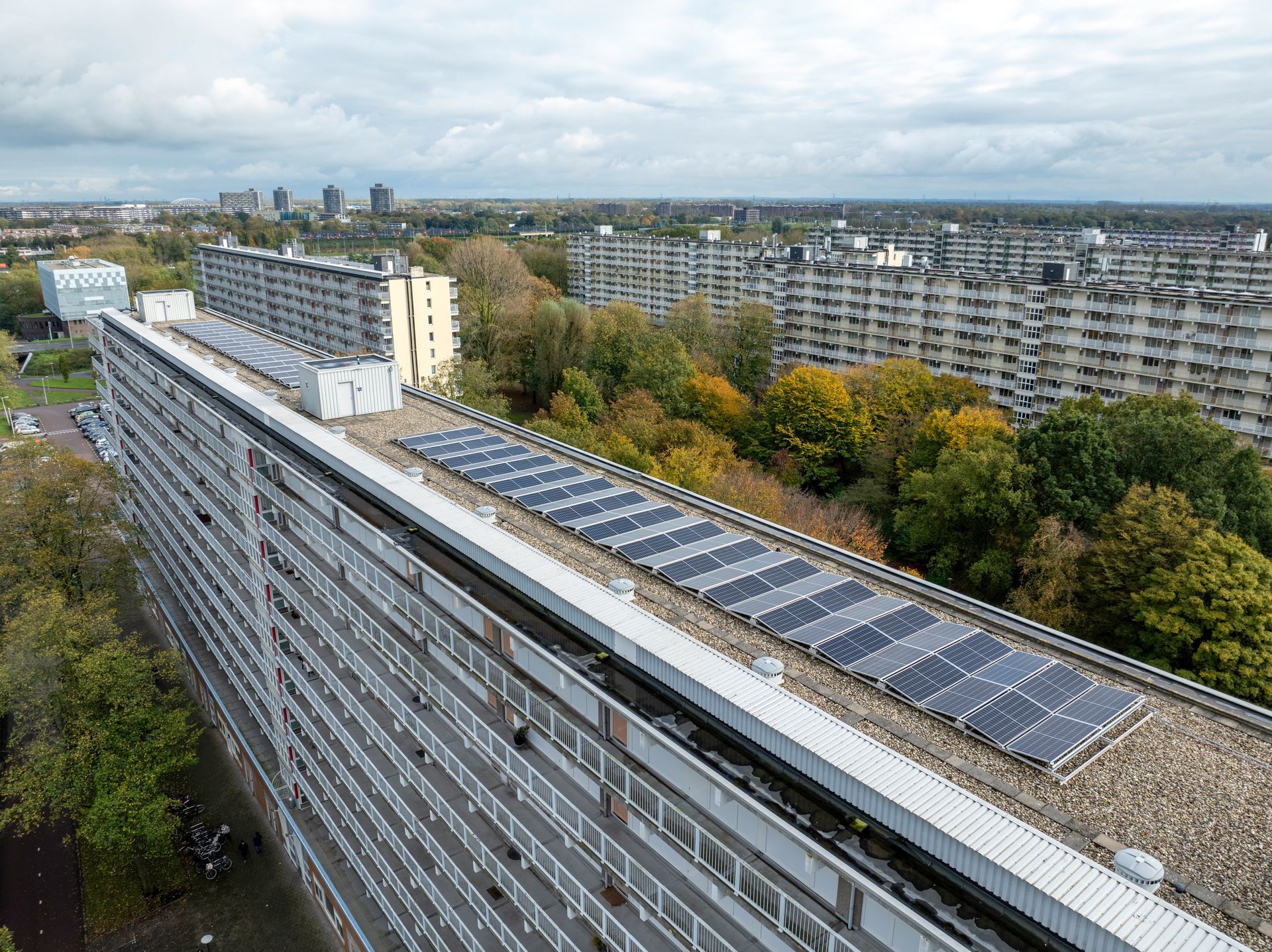 Een luchtfoto van een groot gebouw met zonnepanelen op het dak.