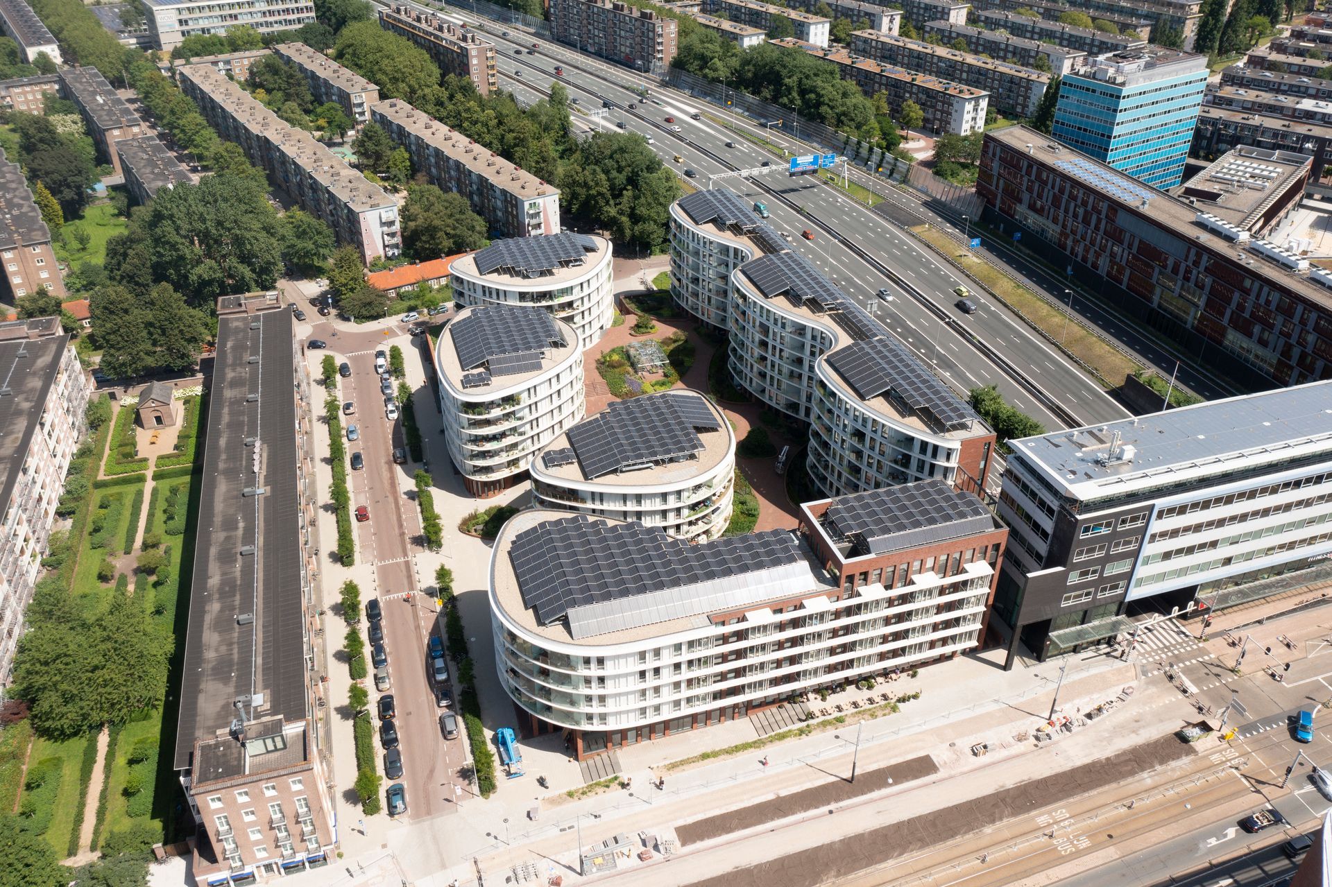 Een luchtfoto van een stad met veel gebouwen en zonnepanelen op de daken.