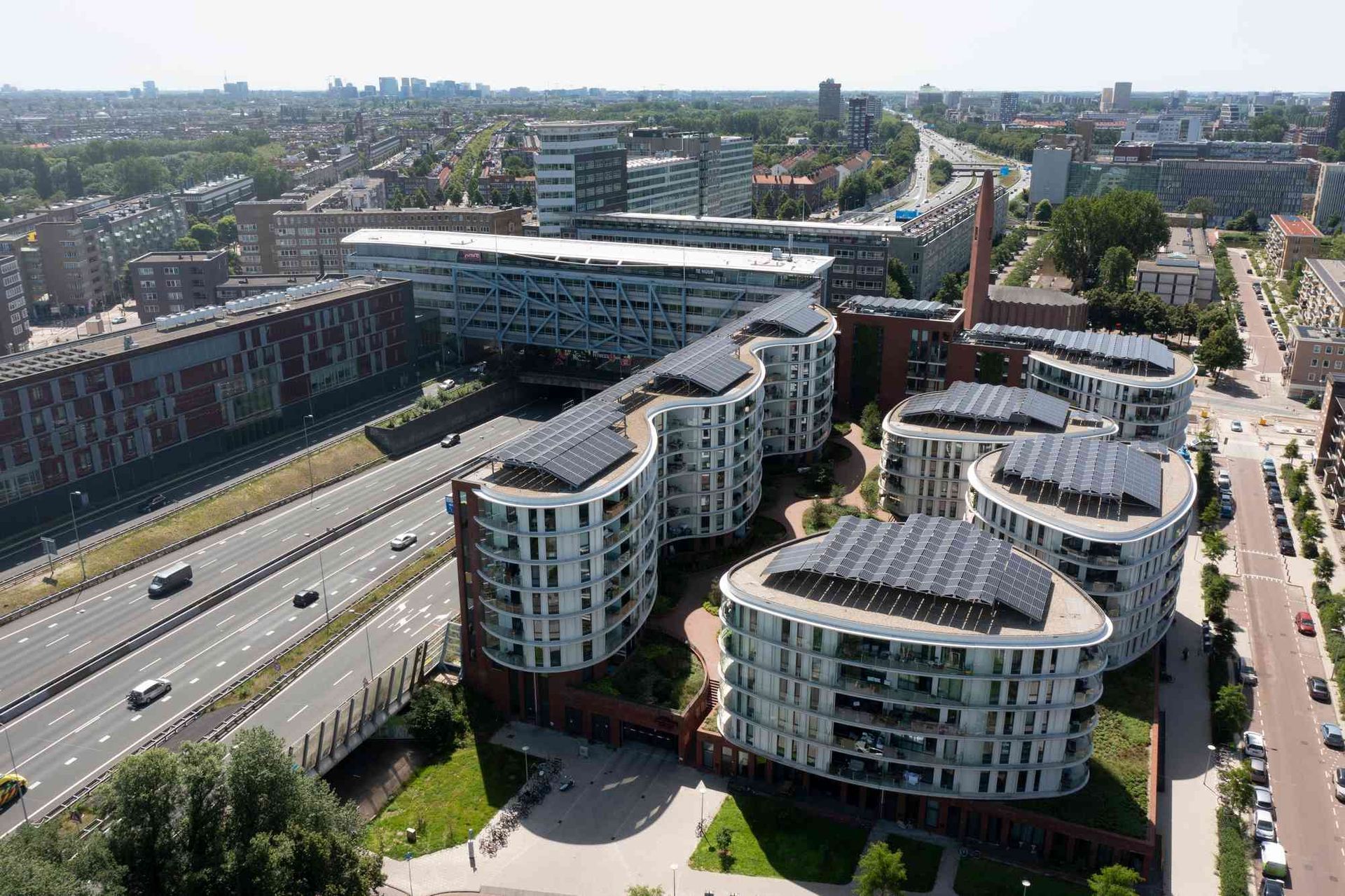 Een luchtfoto van een stad met veel gebouwen en een snelweg
