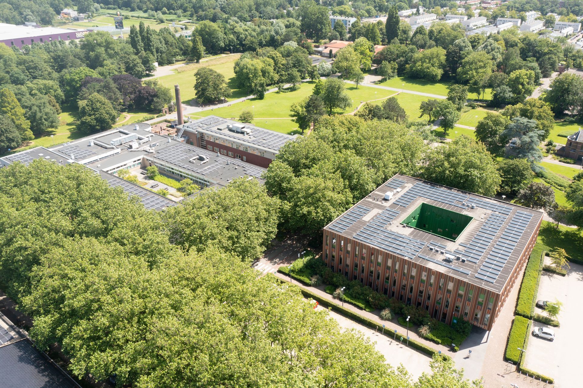 Een luchtfoto van een groot gebouw omgeven door bomen.