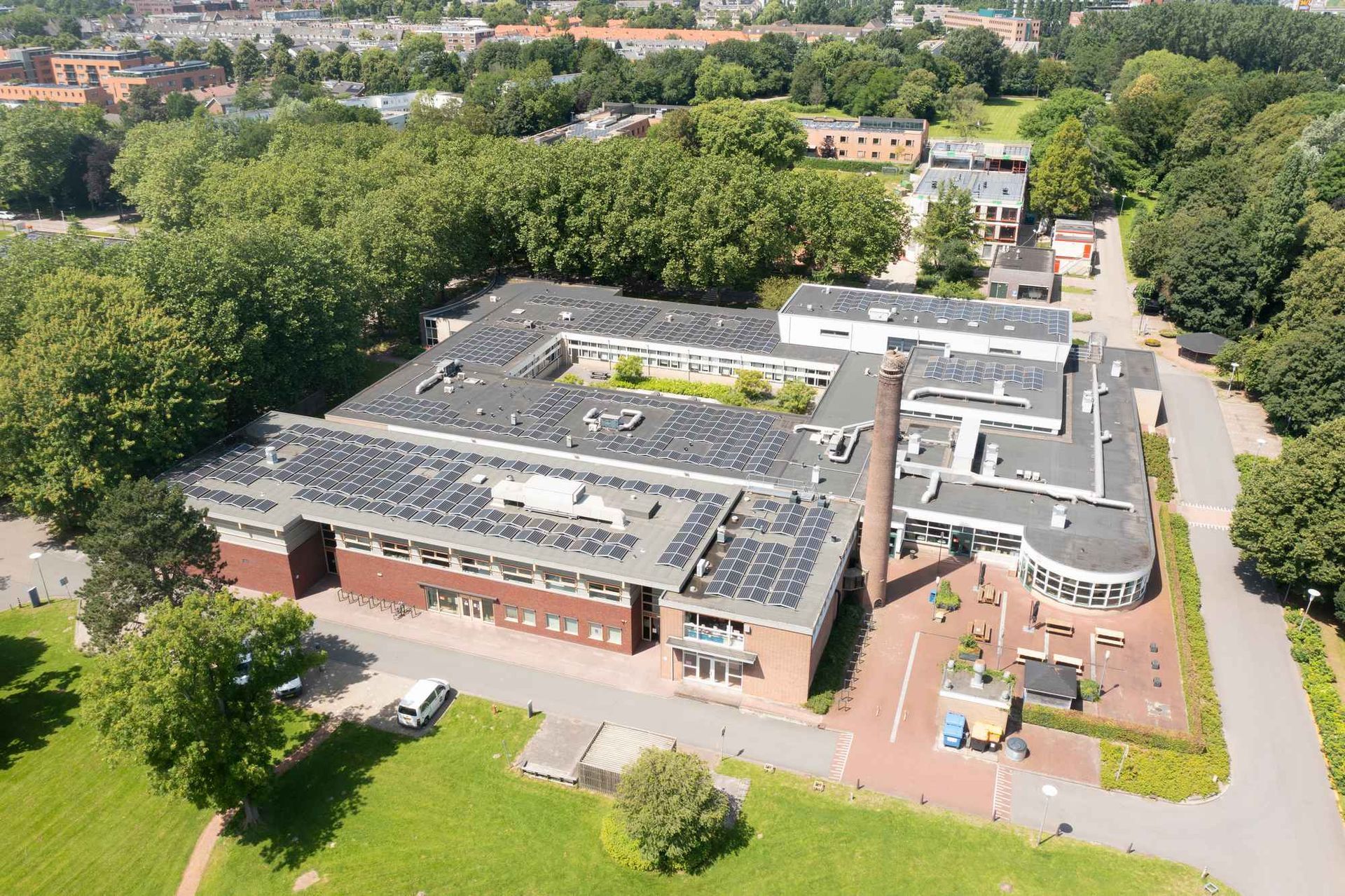 Een luchtfoto van een groot gebouw met zonnepanelen op het dak