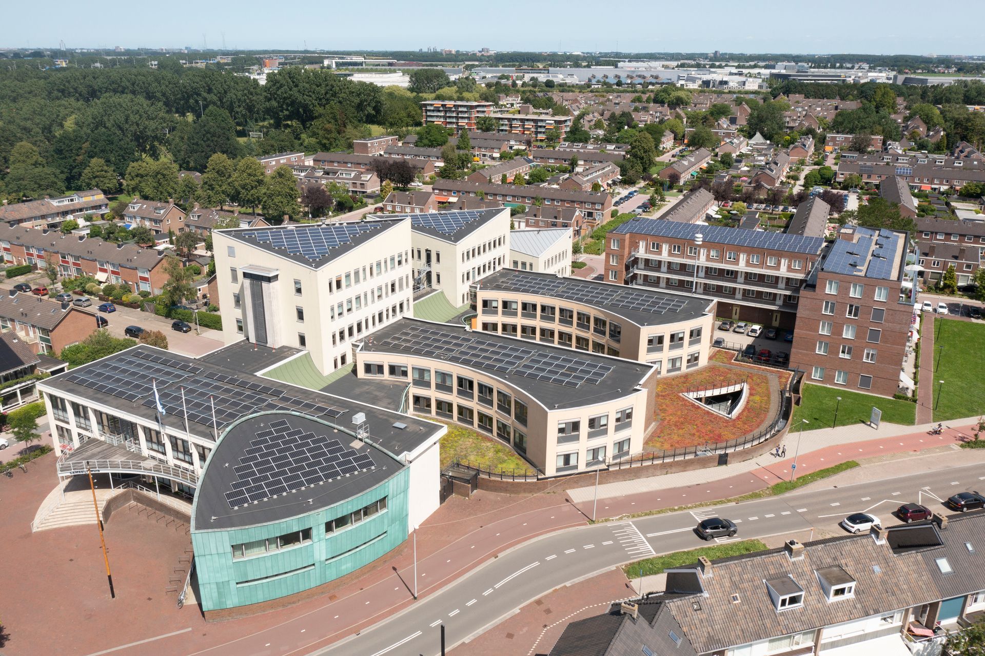 Een luchtfoto van een groot gebouw met zonnepanelen op het dak.