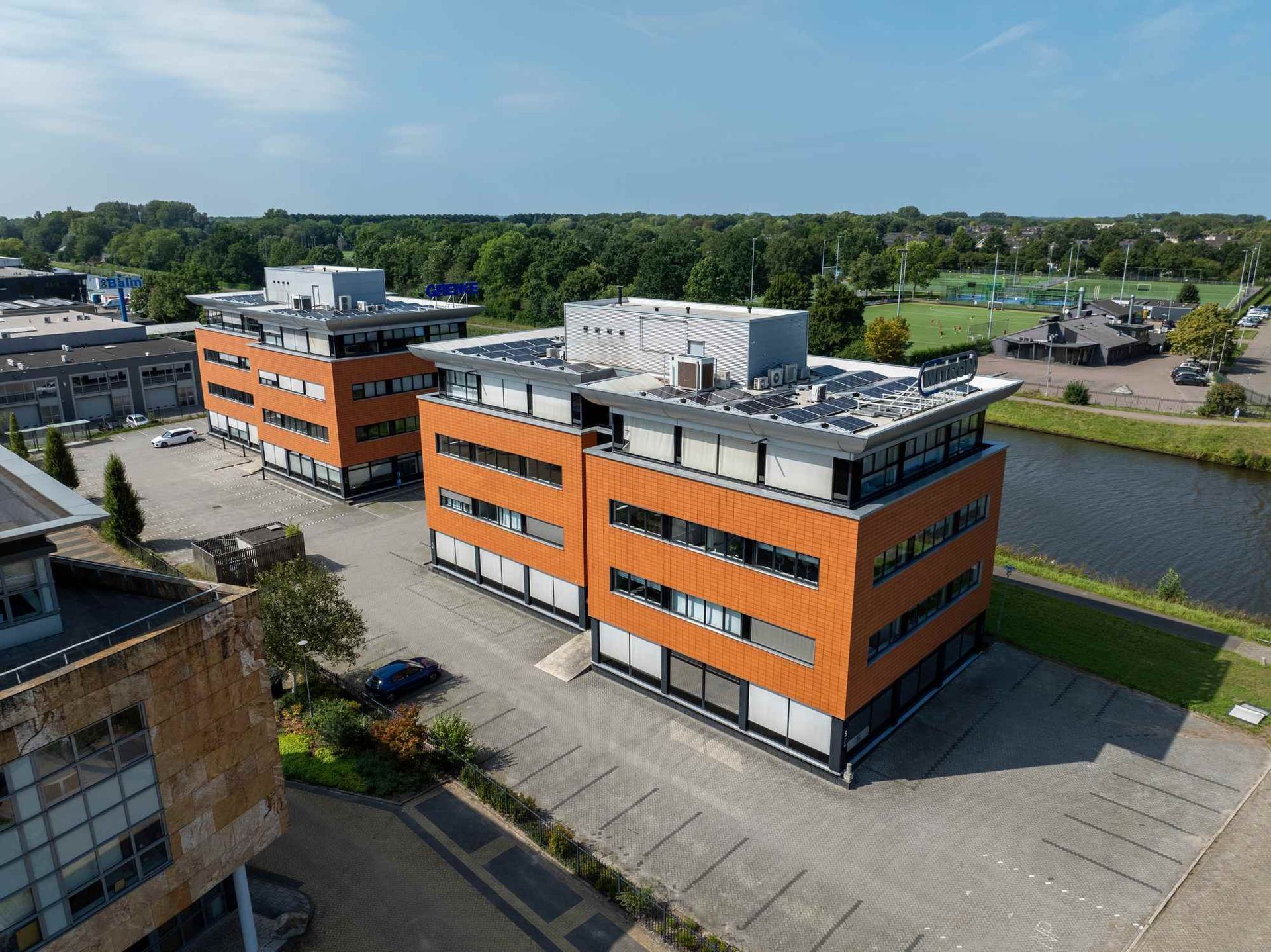 Een luchtfoto van een groot oranje gebouw naast een rivier.