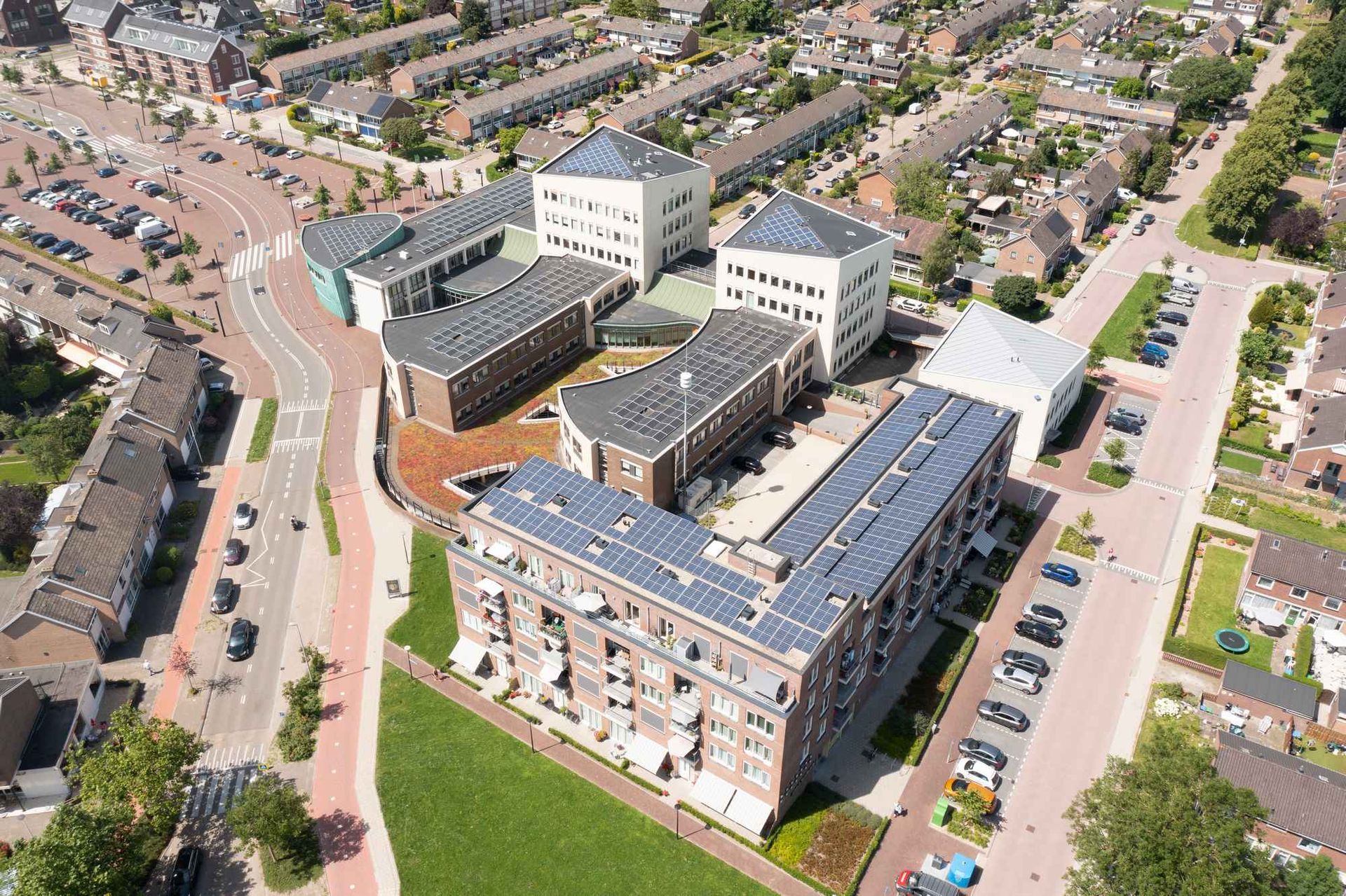 Een luchtfoto van een groot gebouw met zonnepanelen op het dak.