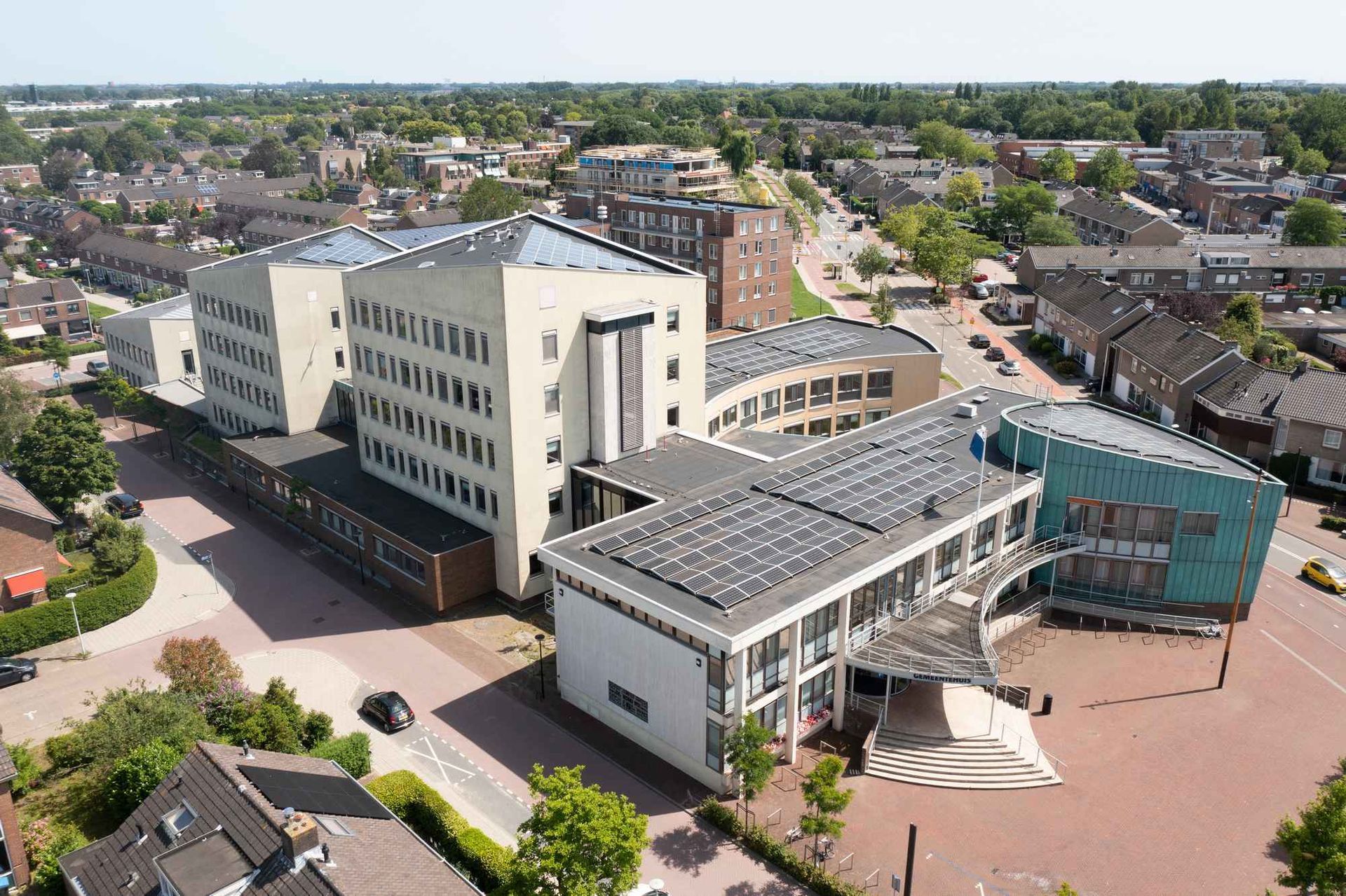 Een luchtfoto van een groot gebouw met zonnepanelen op het dak.