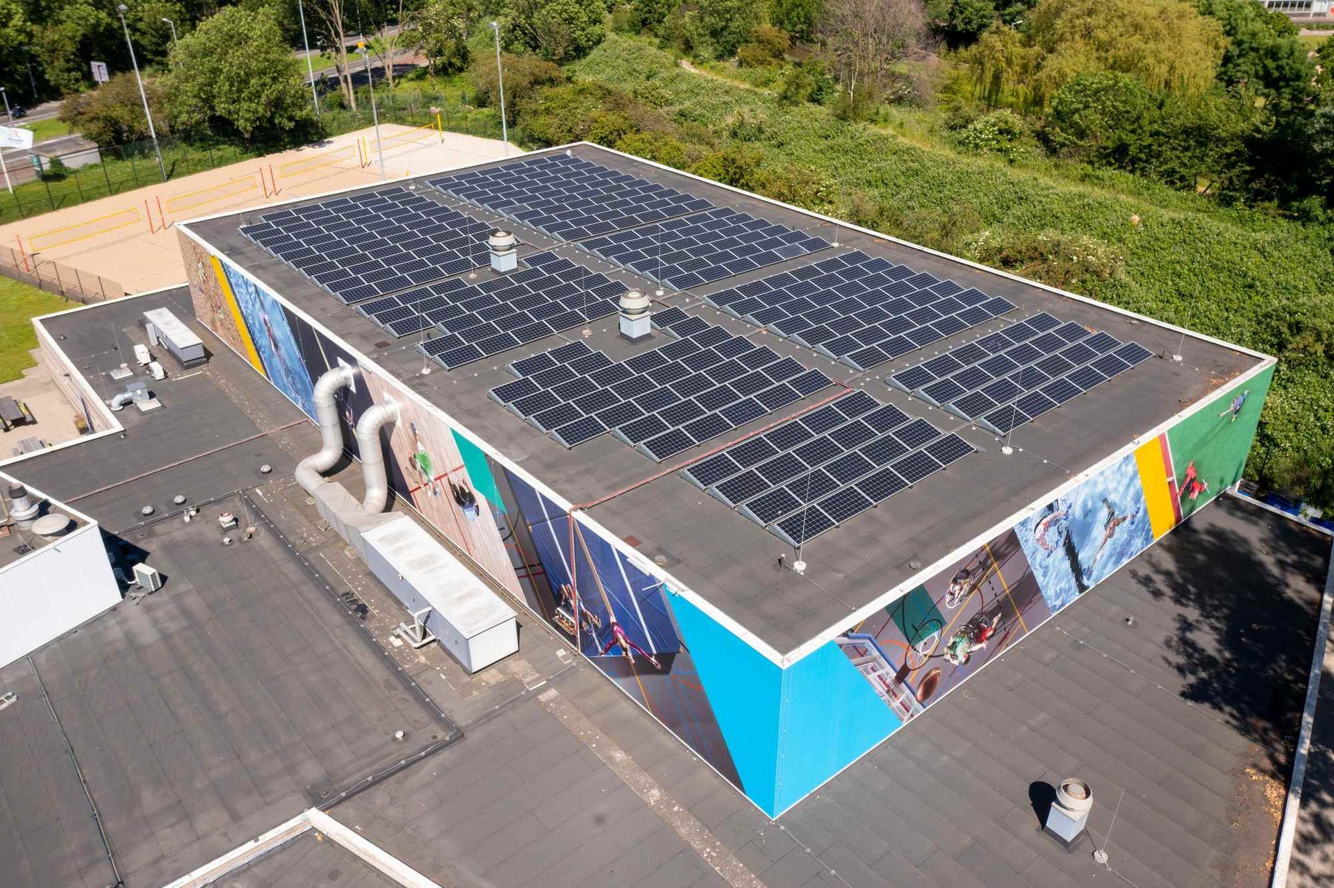 Een luchtfoto van een gebouw met zonnepanelen op het dak.