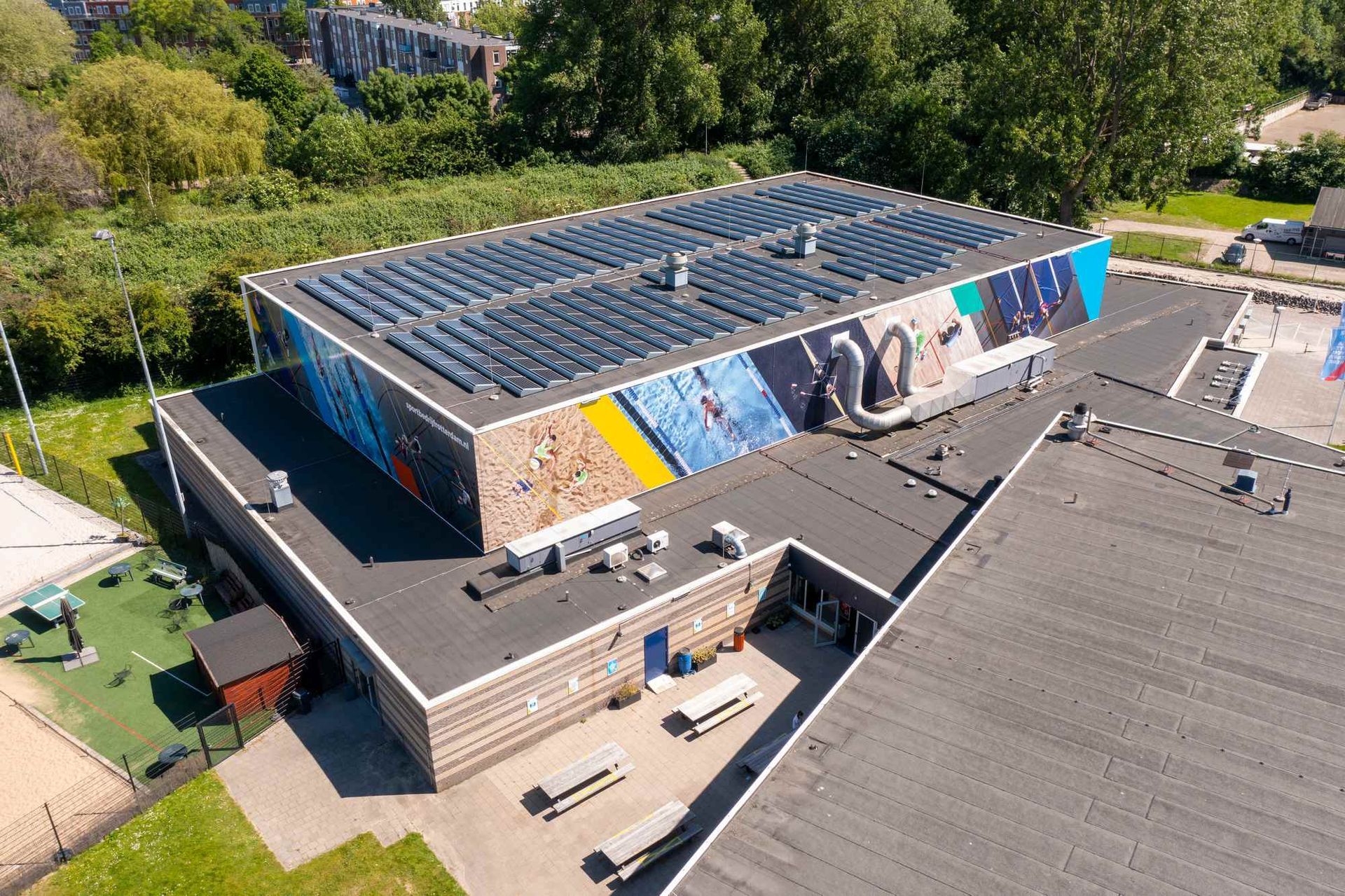 Een luchtfoto van een gebouw met zonnepanelen op het dak.