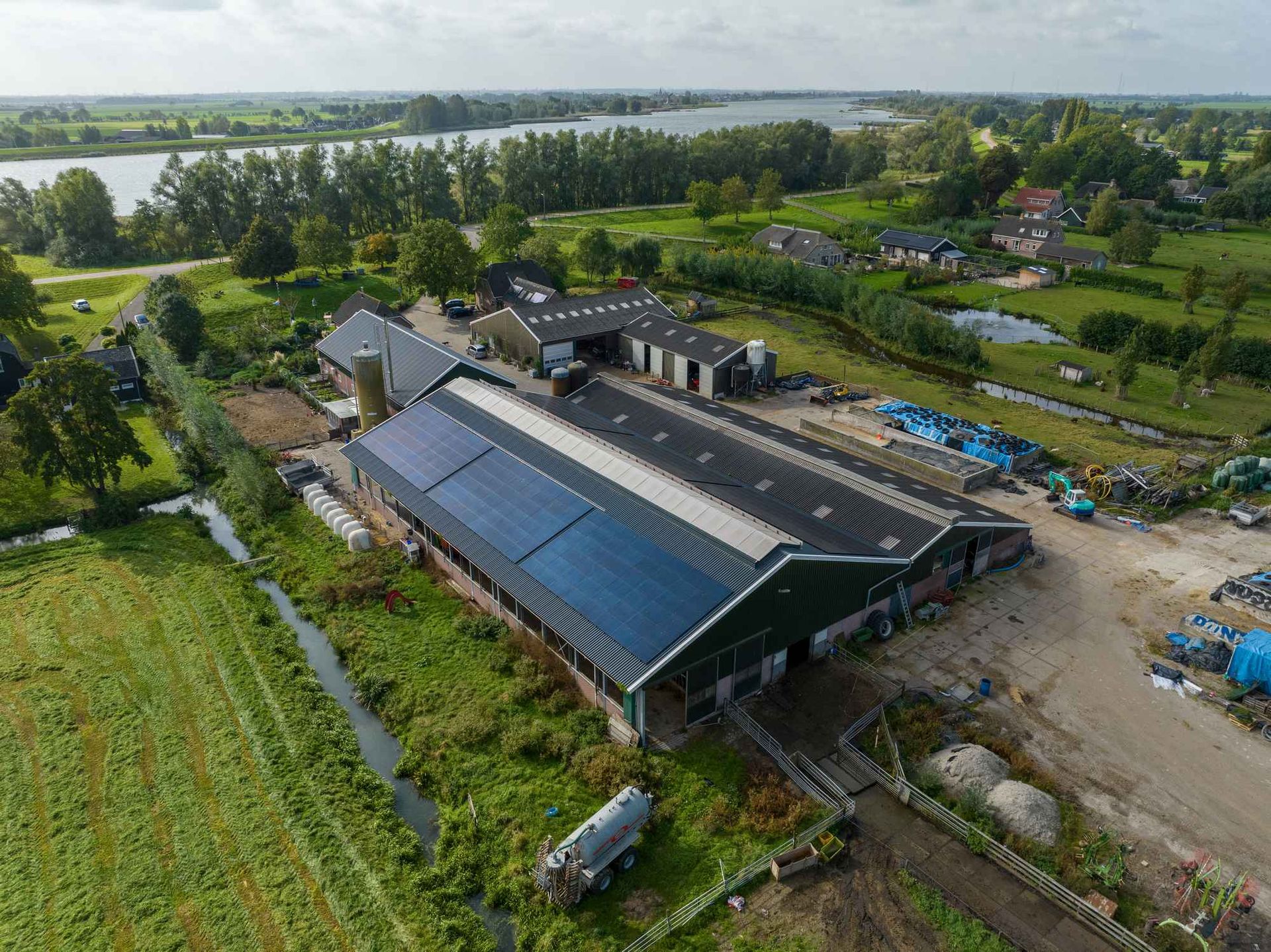 Een luchtfoto van een boerderij met zonnepanelen op het dak.