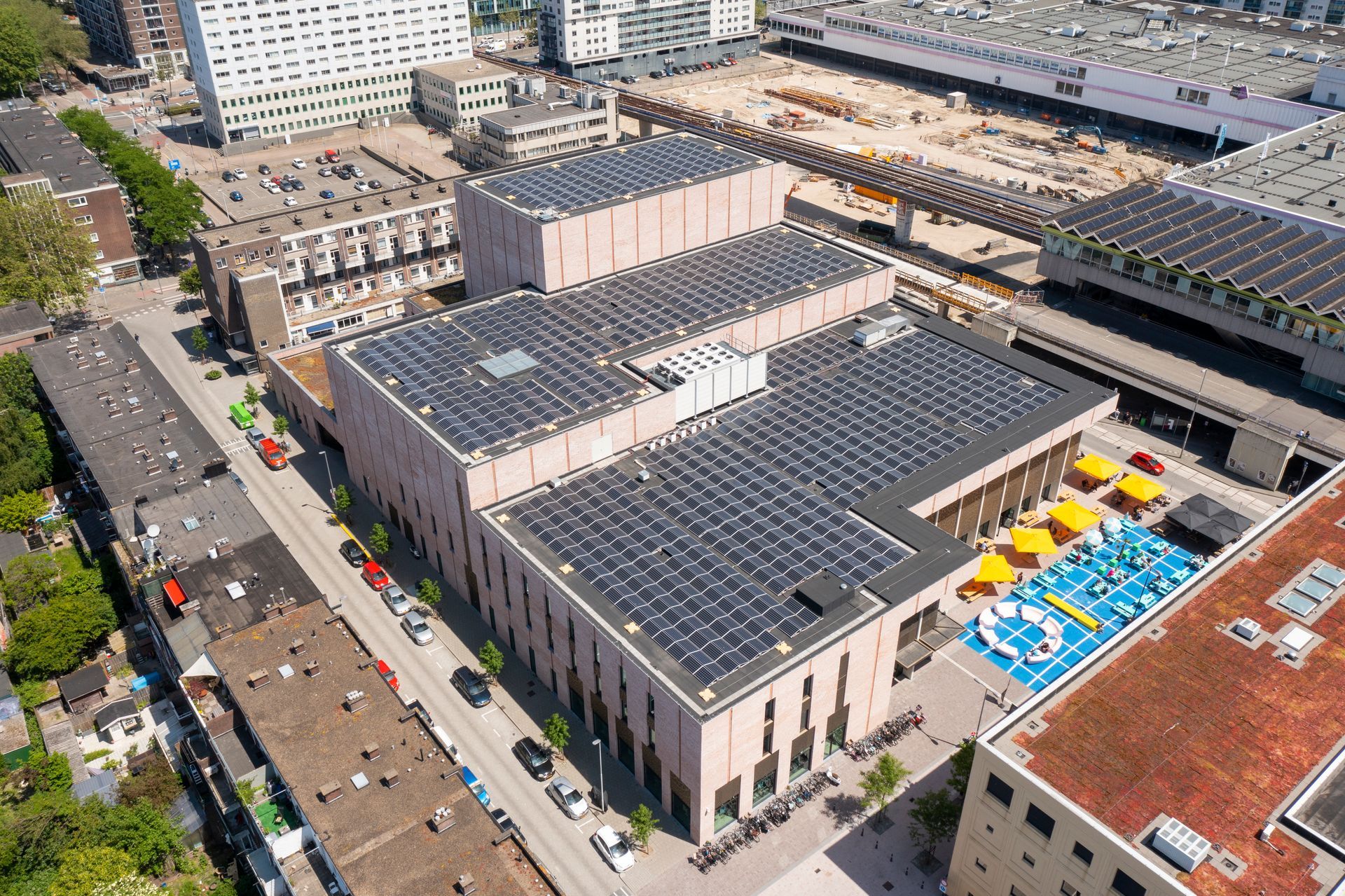 Een luchtfoto van een groot gebouw met zonnepanelen op het dak.