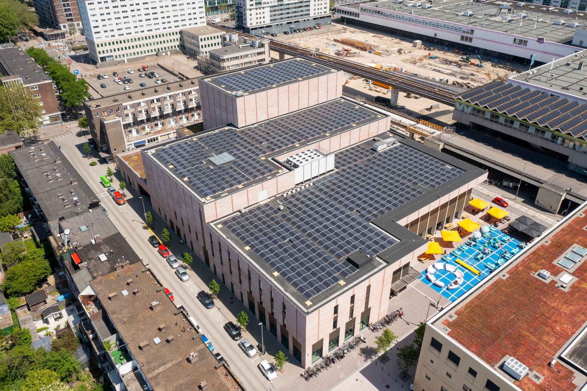 Een luchtfoto van een groot gebouw met zonnepanelen op het dak.