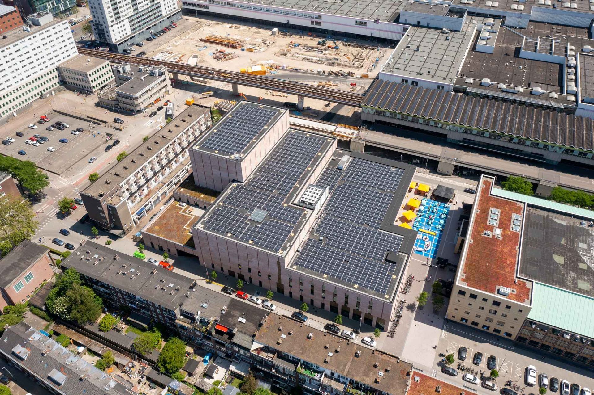 Een luchtfoto van een groot gebouw met zonnepanelen op het dak.