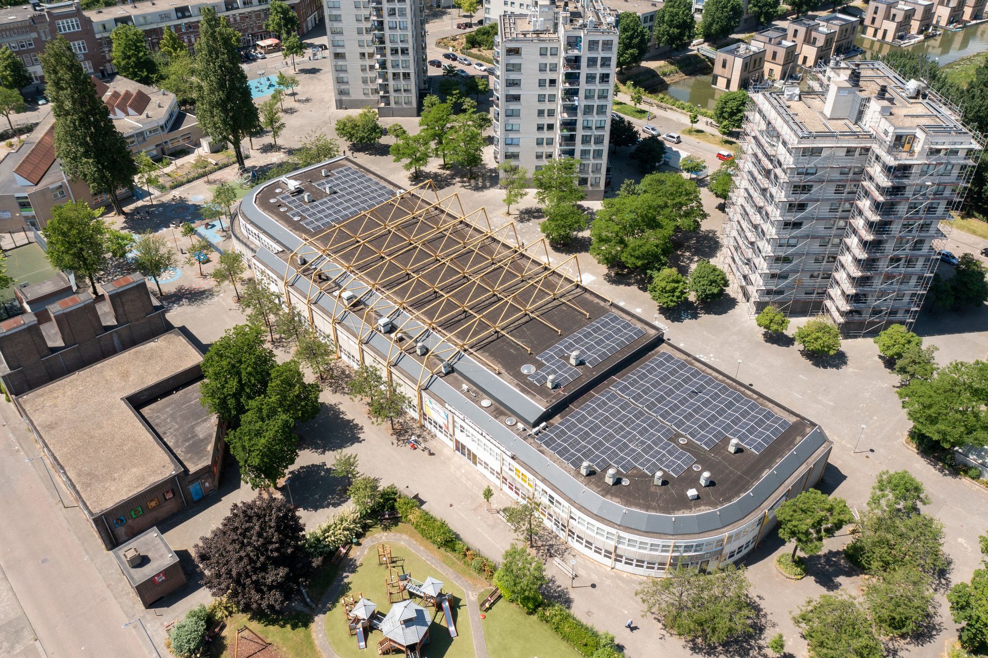 Een luchtfoto van een groot gebouw met zonnepanelen op het dak.