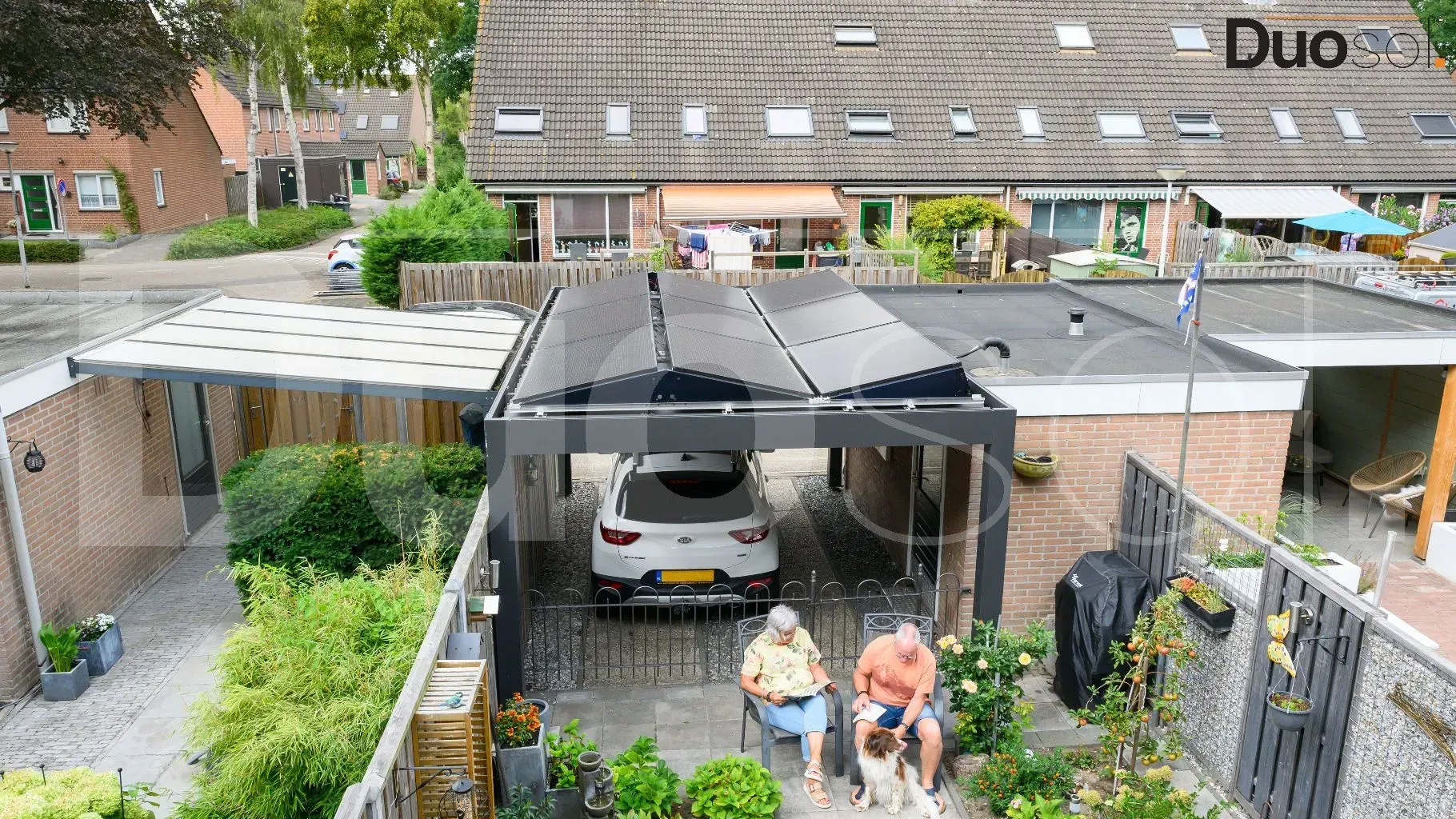 Een paar mensen zitten onder een afdak voor een auto.