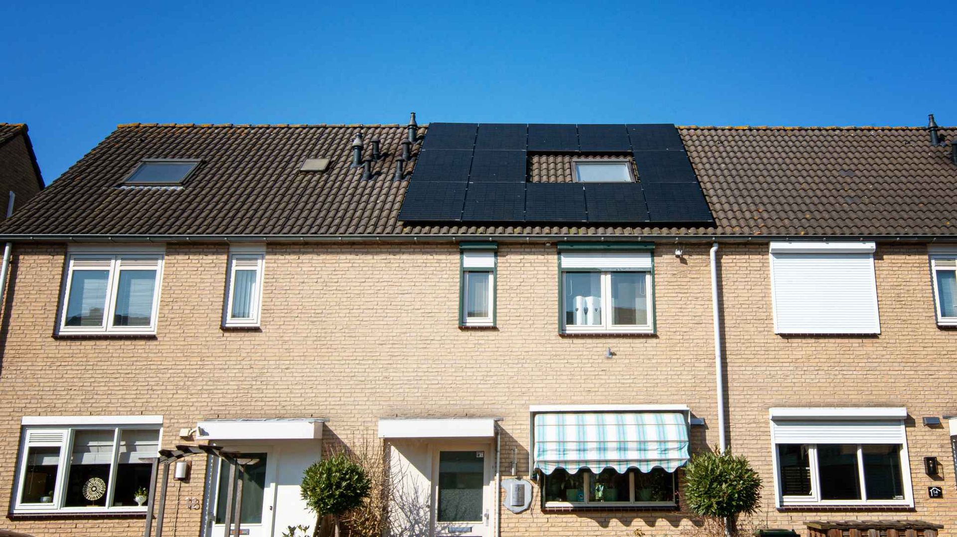 Een rij huizen met zonnepanelen op het dak