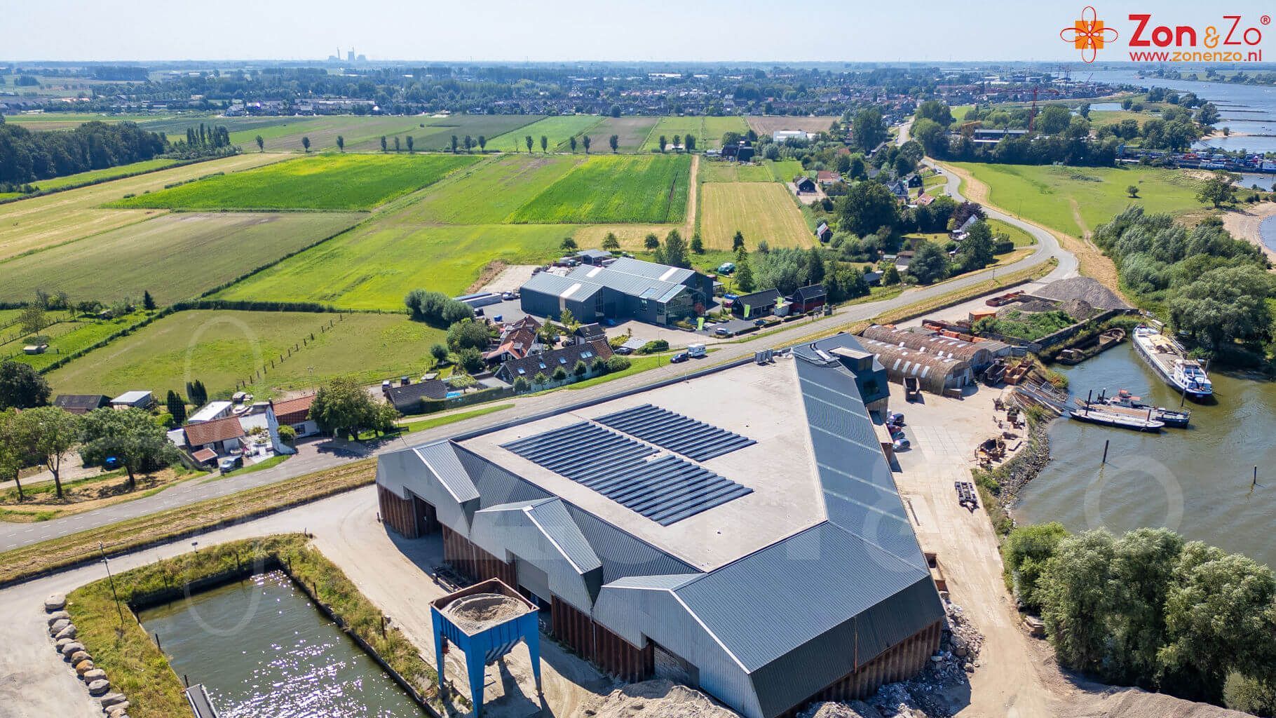 Een luchtfoto van een groot gebouw met zonnepanelen op het dak