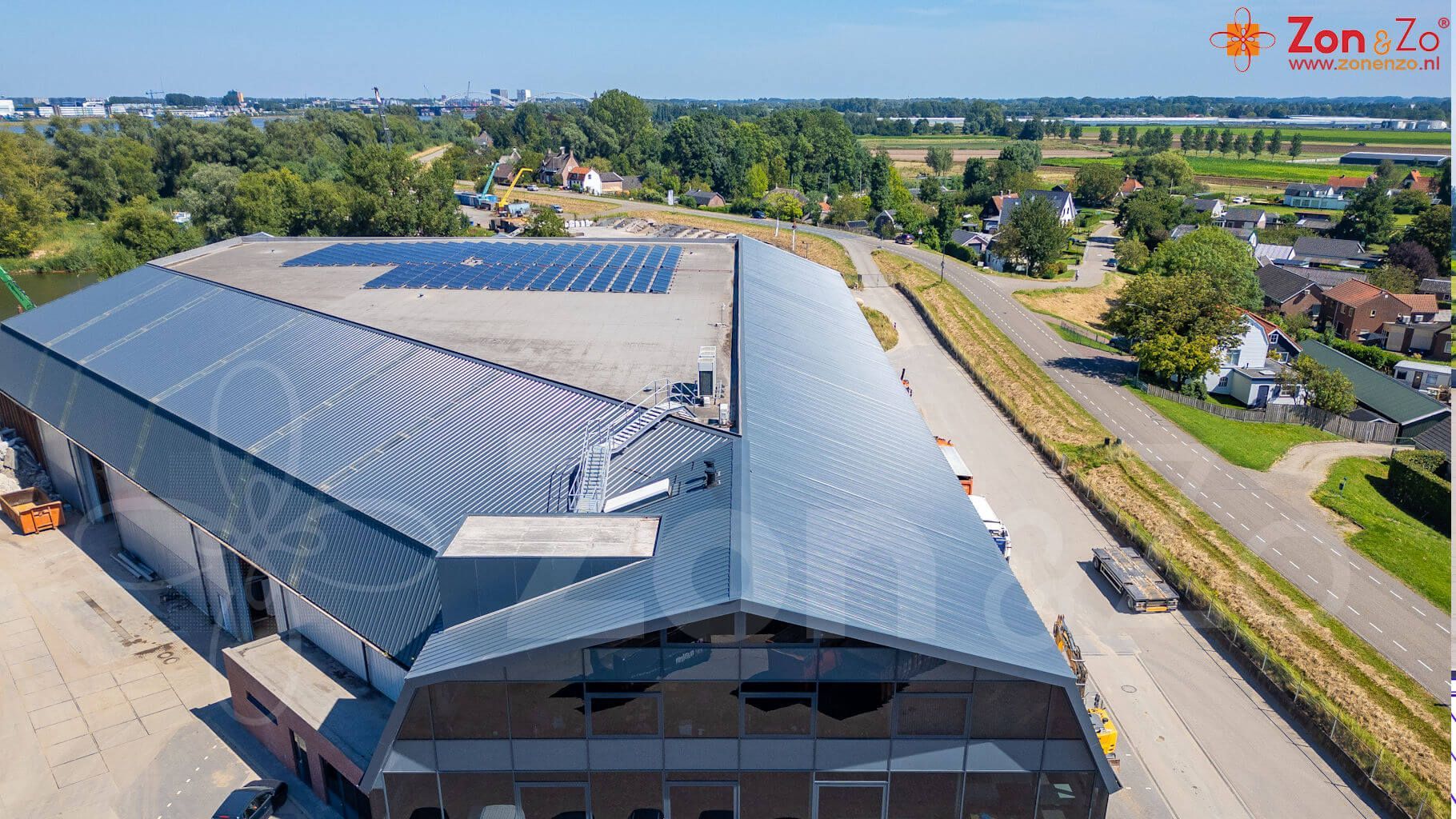 Een luchtfoto van een groot gebouw met zonnepanelen op het dak.