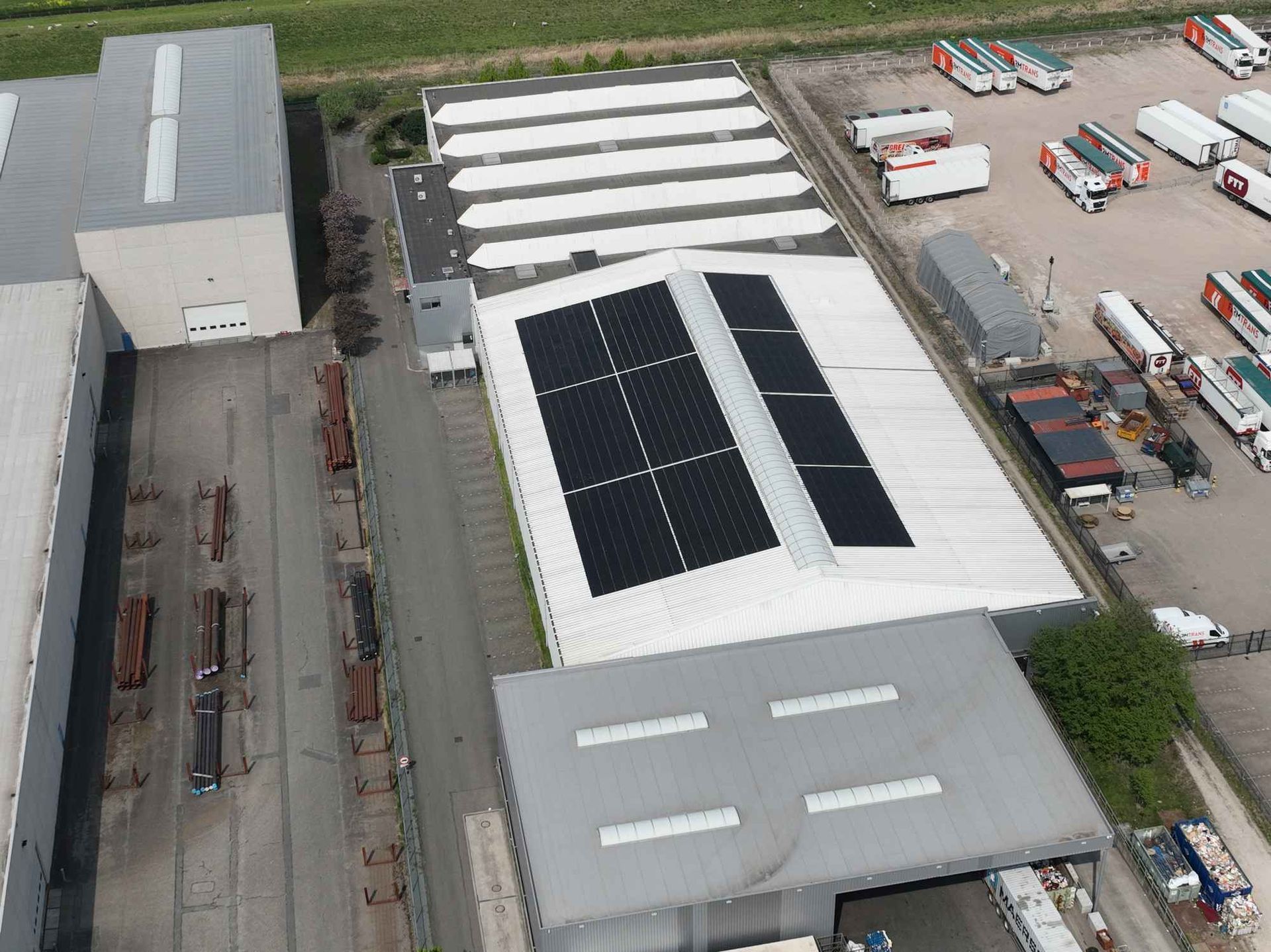 Een luchtfoto van een groot gebouw met zonnepanelen op het dak.