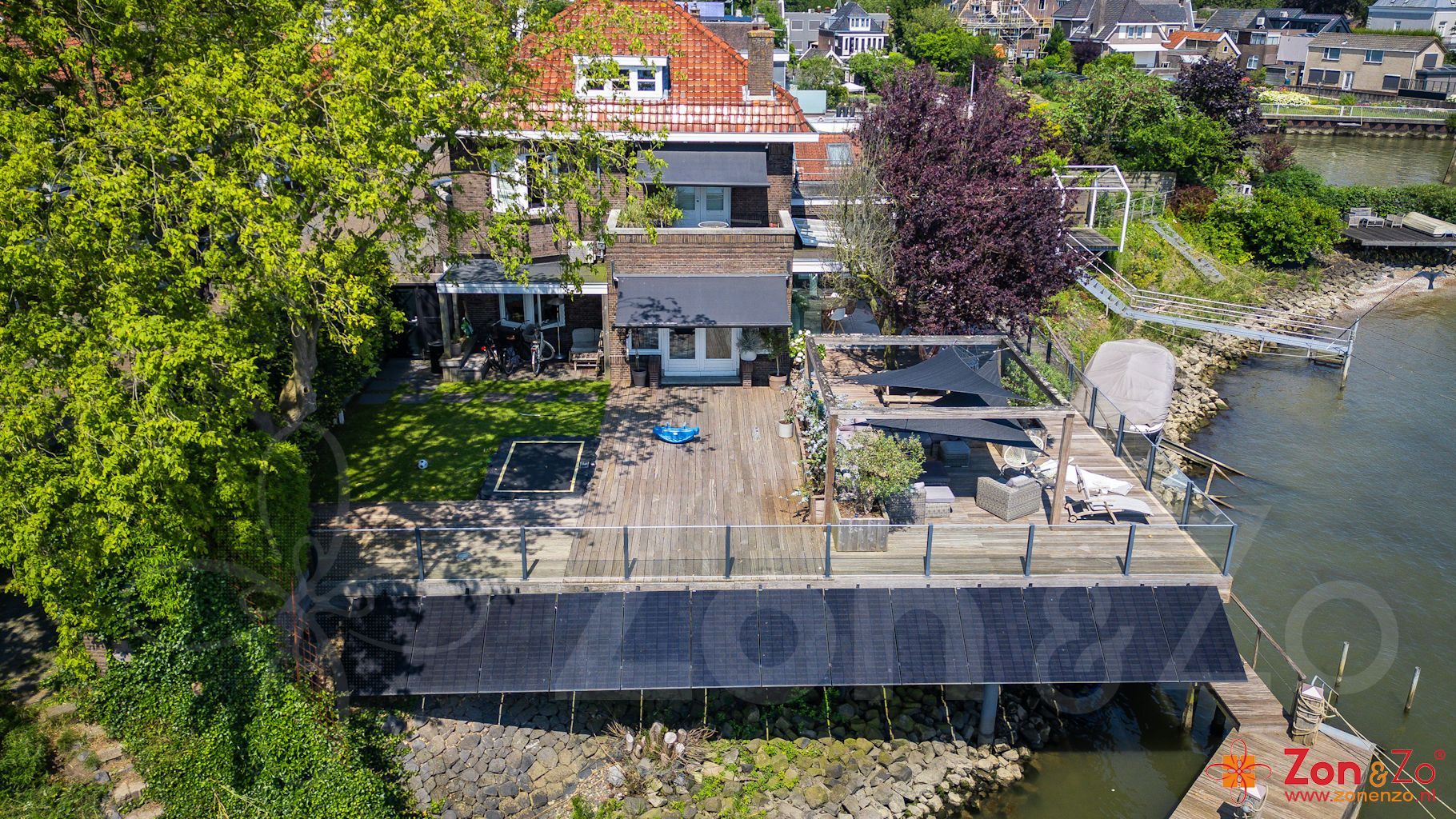Een luchtfoto van een huis op palen met uitzicht op een waterpartij.