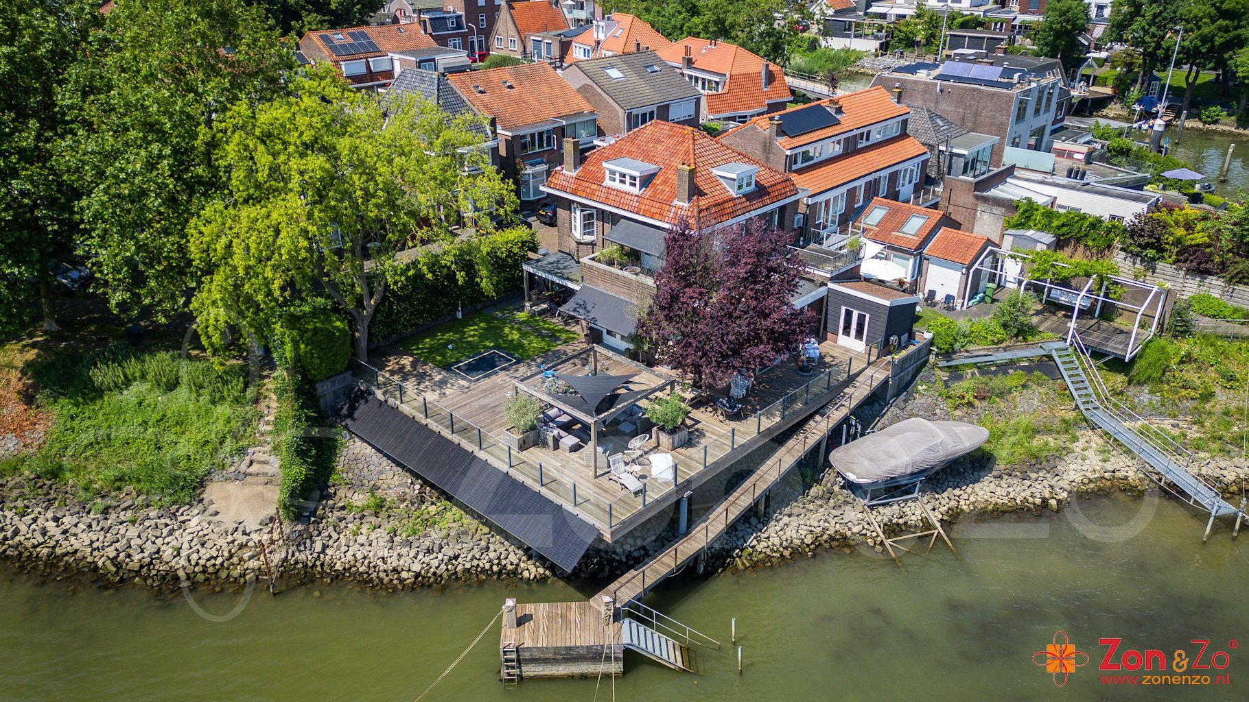 Een luchtfoto van een huis aan de oever van een rivier.