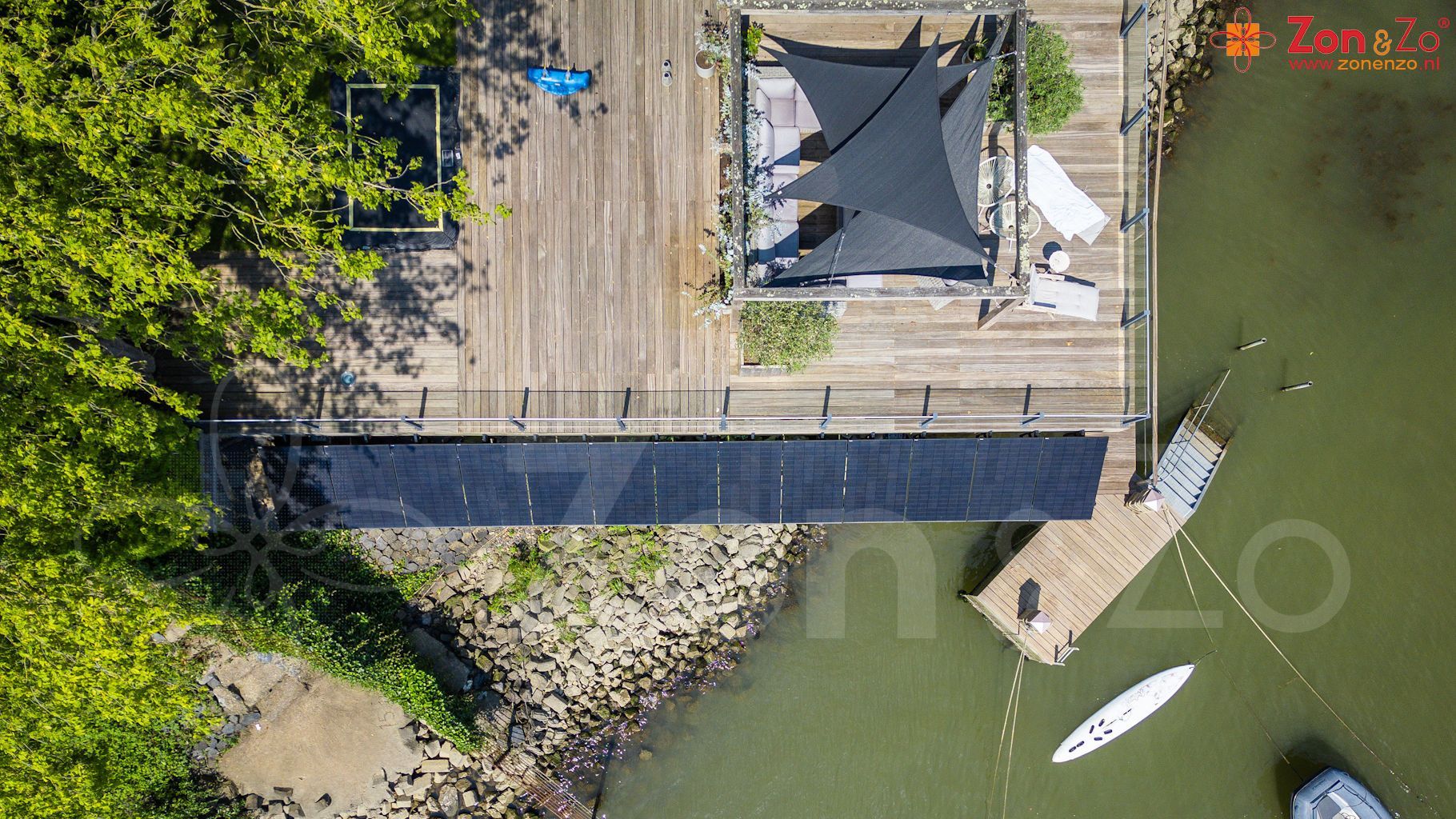 Een luchtfoto van een huis op een steiger naast een waterpartij.