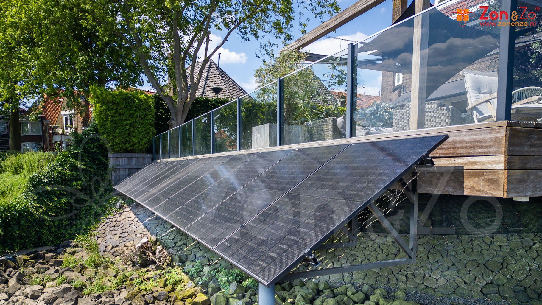 Een zonnepaneel ligt op de top van een rotsachtige heuvel naast een huis.