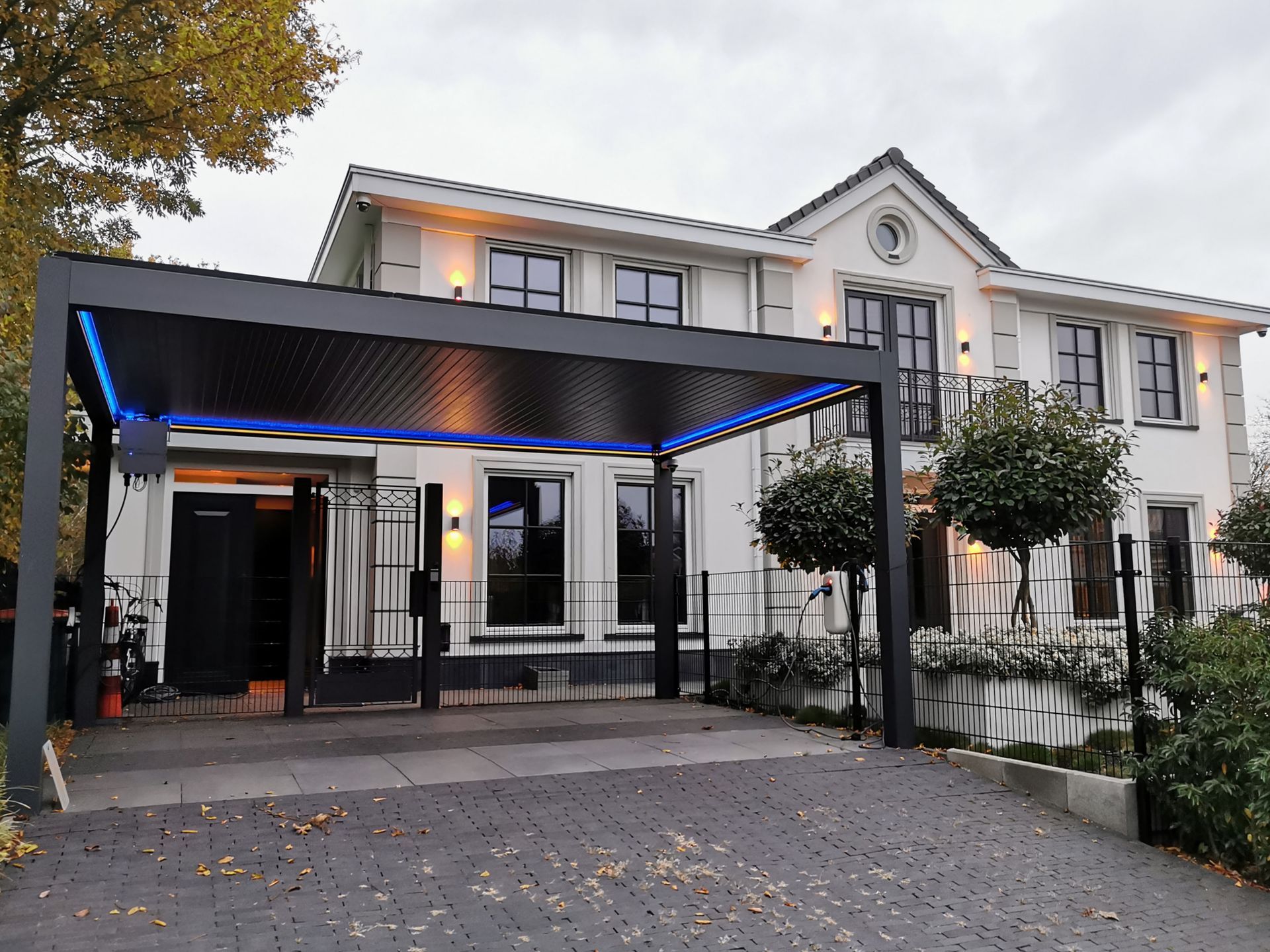 Een groot wit huis met een oprit die ernaartoe leidt