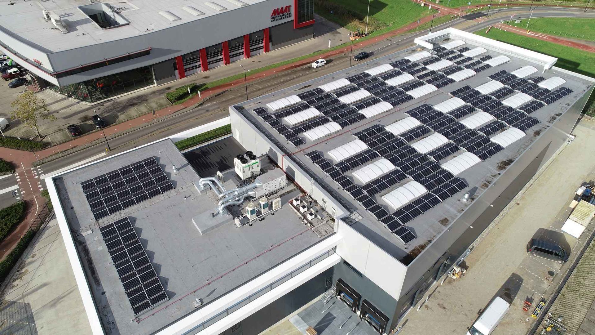 Een luchtfoto van een groot gebouw met zonnepanelen op het dak.