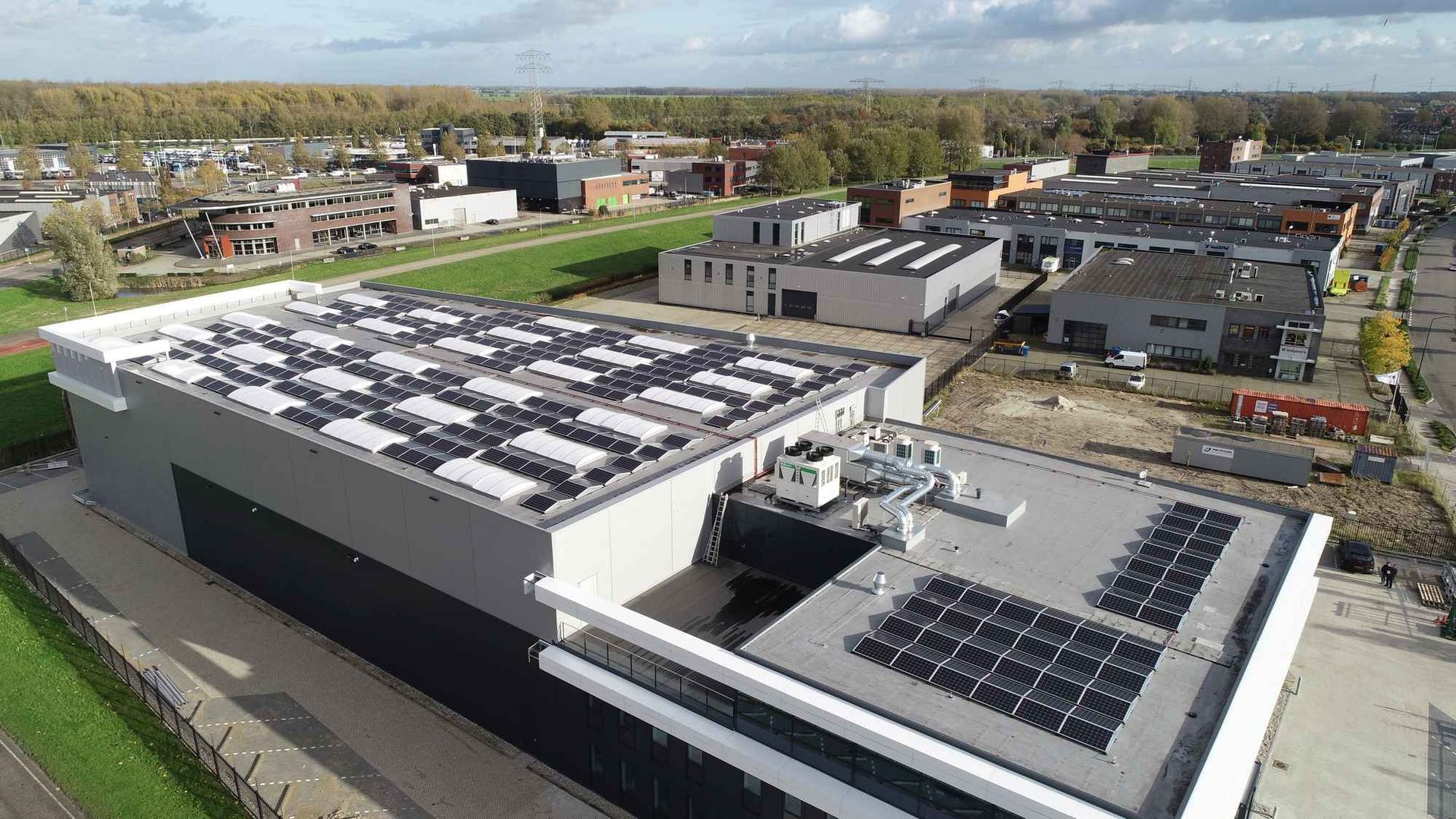 Een luchtfoto van een gebouw met zonnepanelen op het dak.