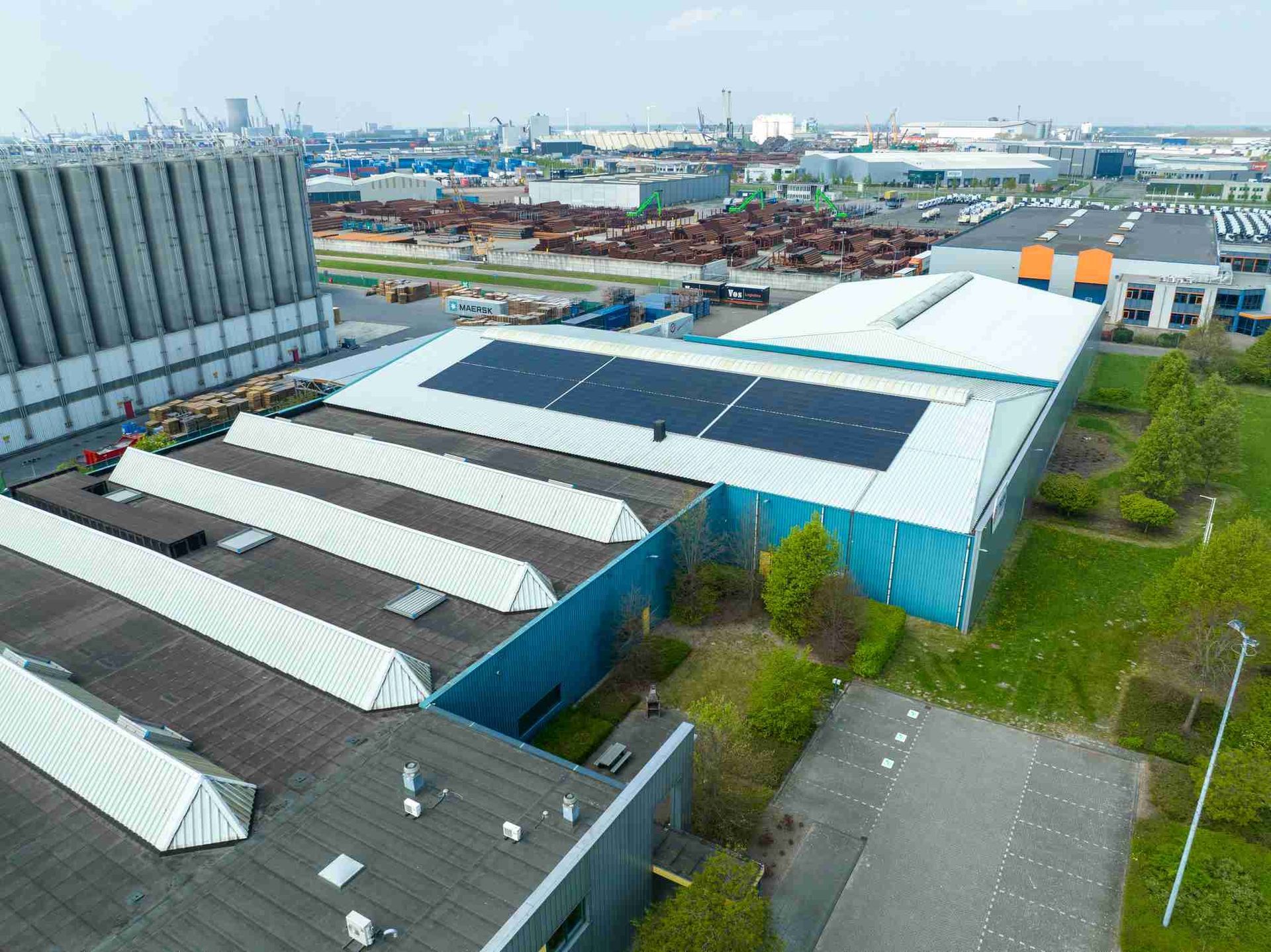 Een luchtfoto van een groot gebouw met zonnepanelen op het dak.