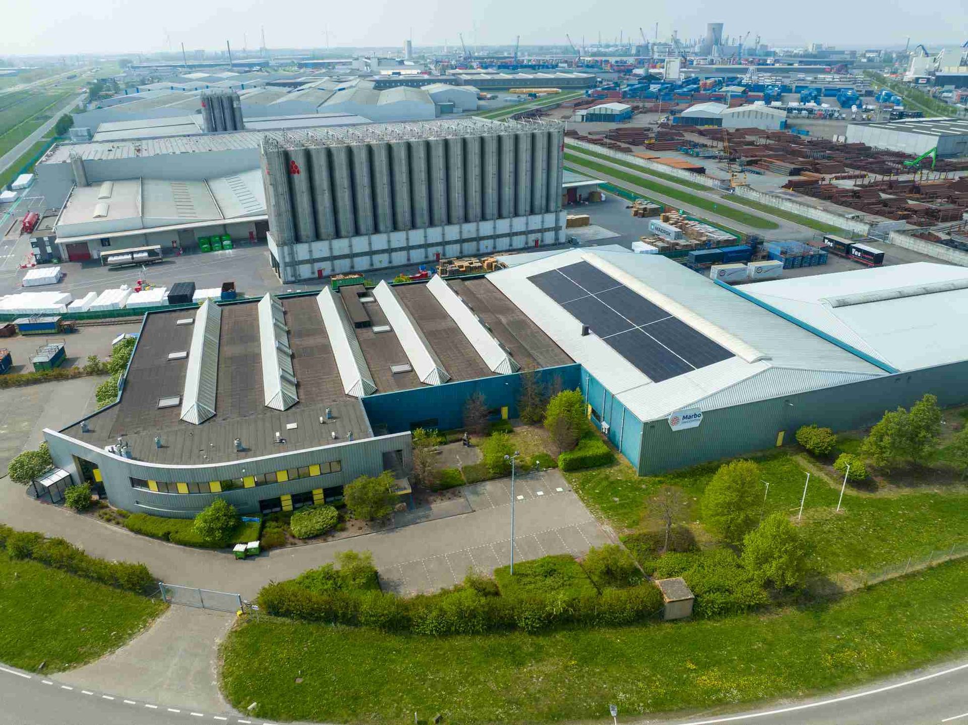 Een luchtfoto van een groot gebouw met zonnepanelen op het dak.