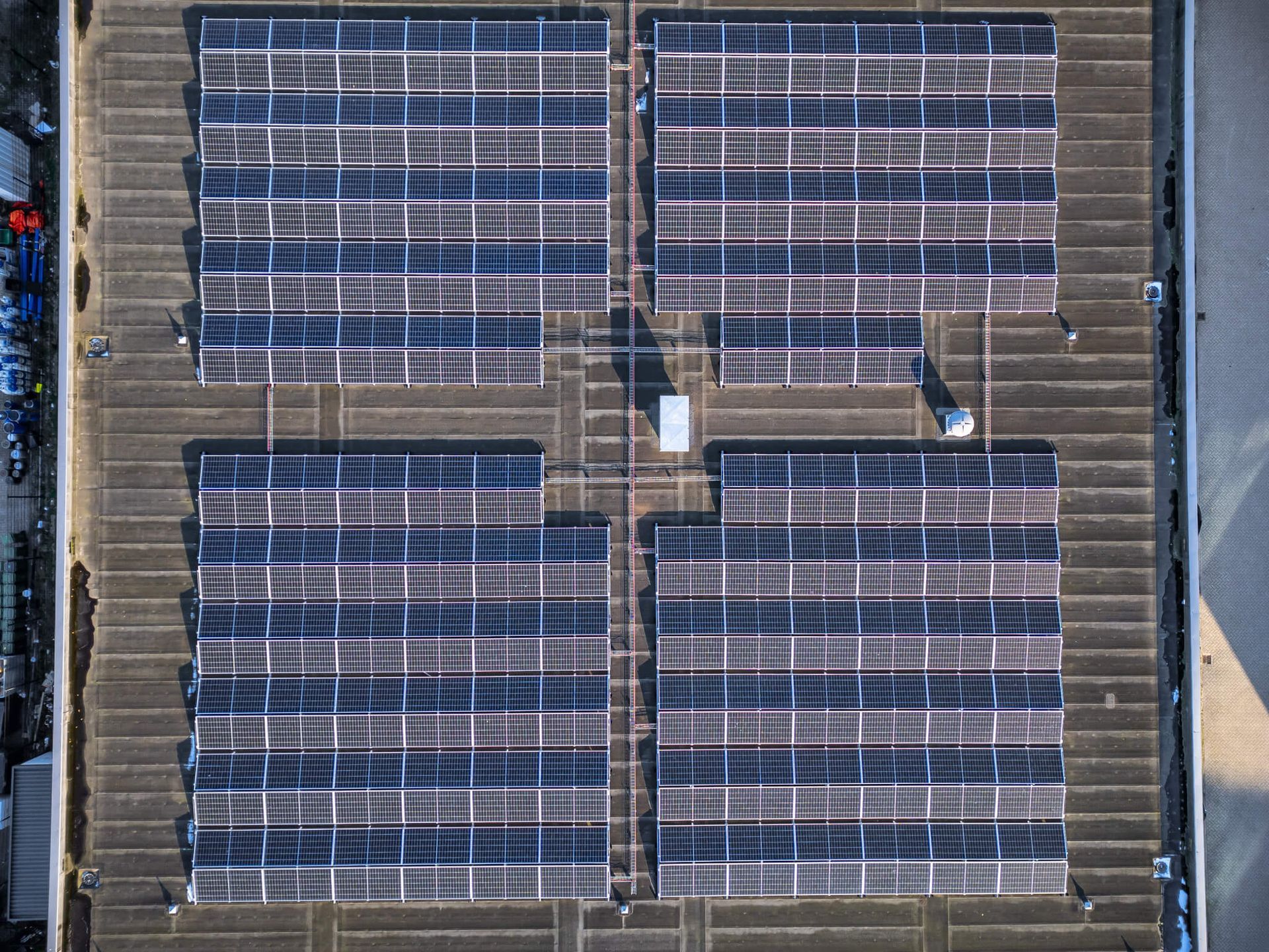 Een luchtfoto van een dak met veel zonnepanelen erop.