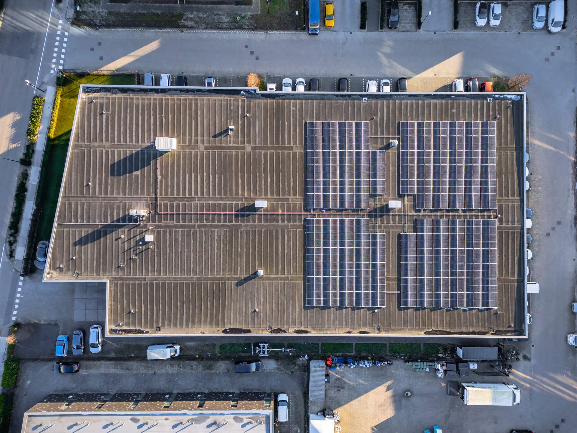 Een luchtfoto van een gebouw met zonnepanelen op het dak.