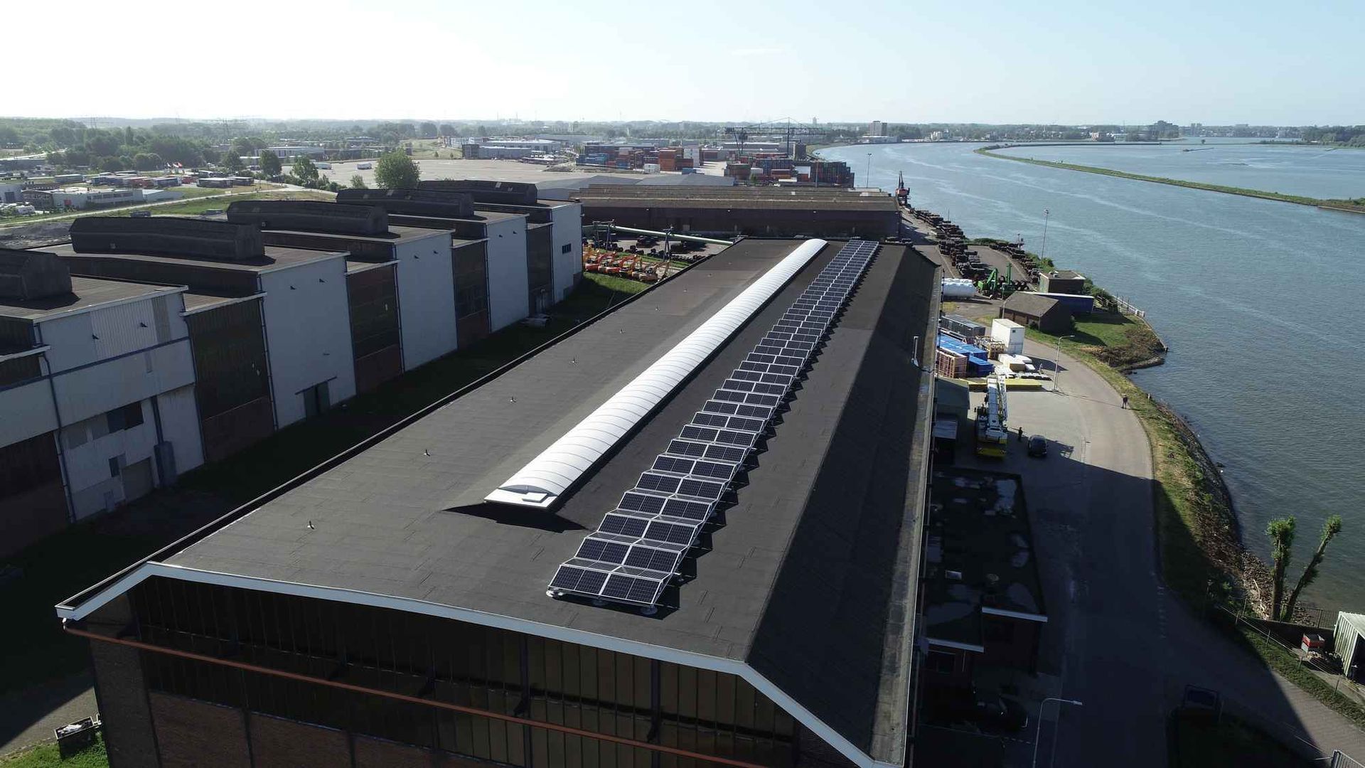 Een luchtfoto van een gebouw met zonnepanelen op het dak.