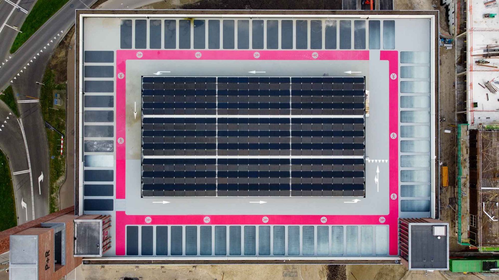 Een luchtfoto van een groot gebouw met zonnepanelen op het dak