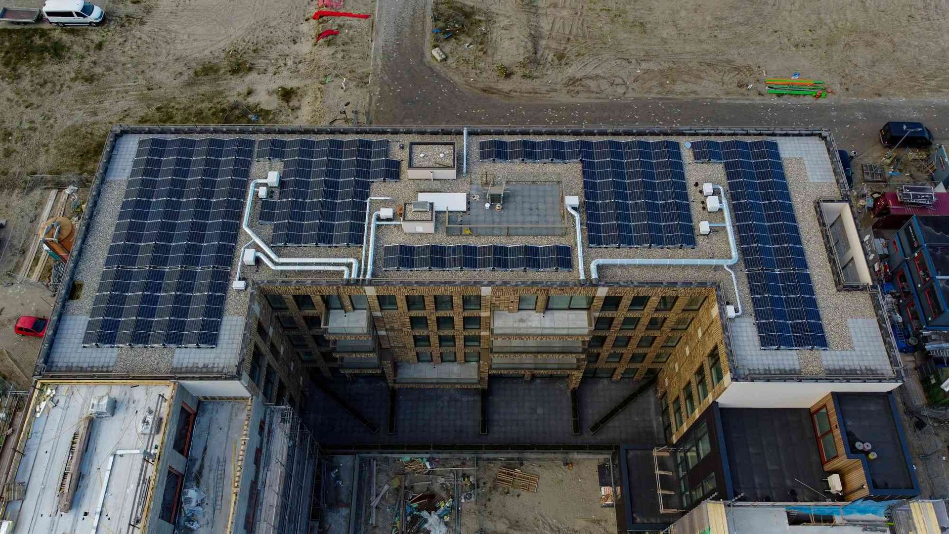 Een luchtfoto van een gebouw met zonnepanelen op het dak.
