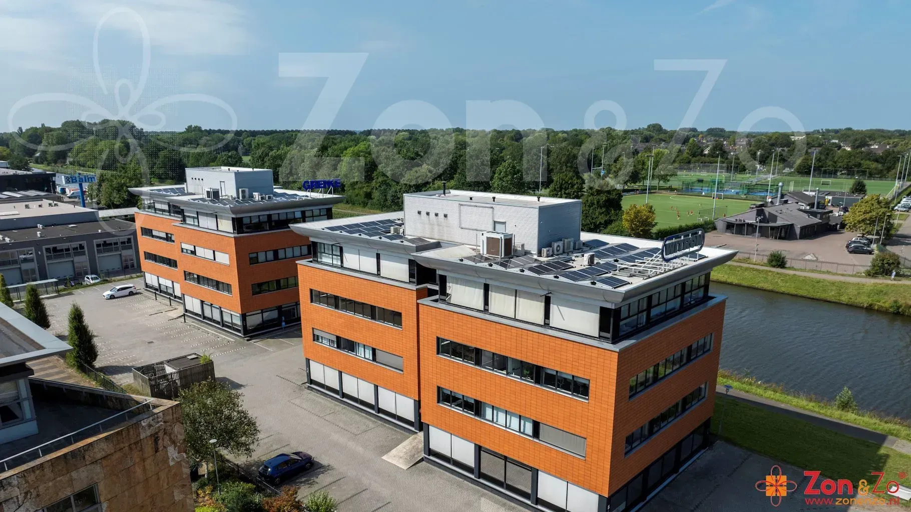 Een luchtfoto van een groot oranje gebouw naast een rivier.