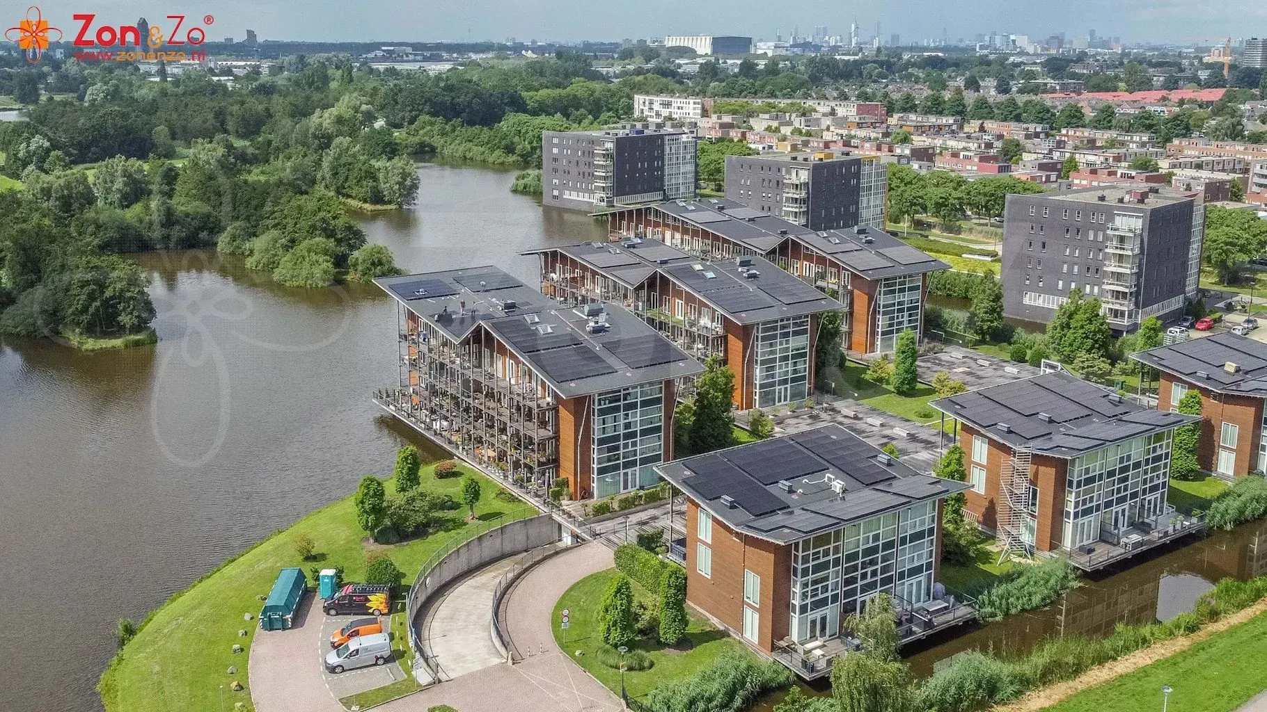 Een luchtfoto van een woonwijk met een meer op de achtergrond