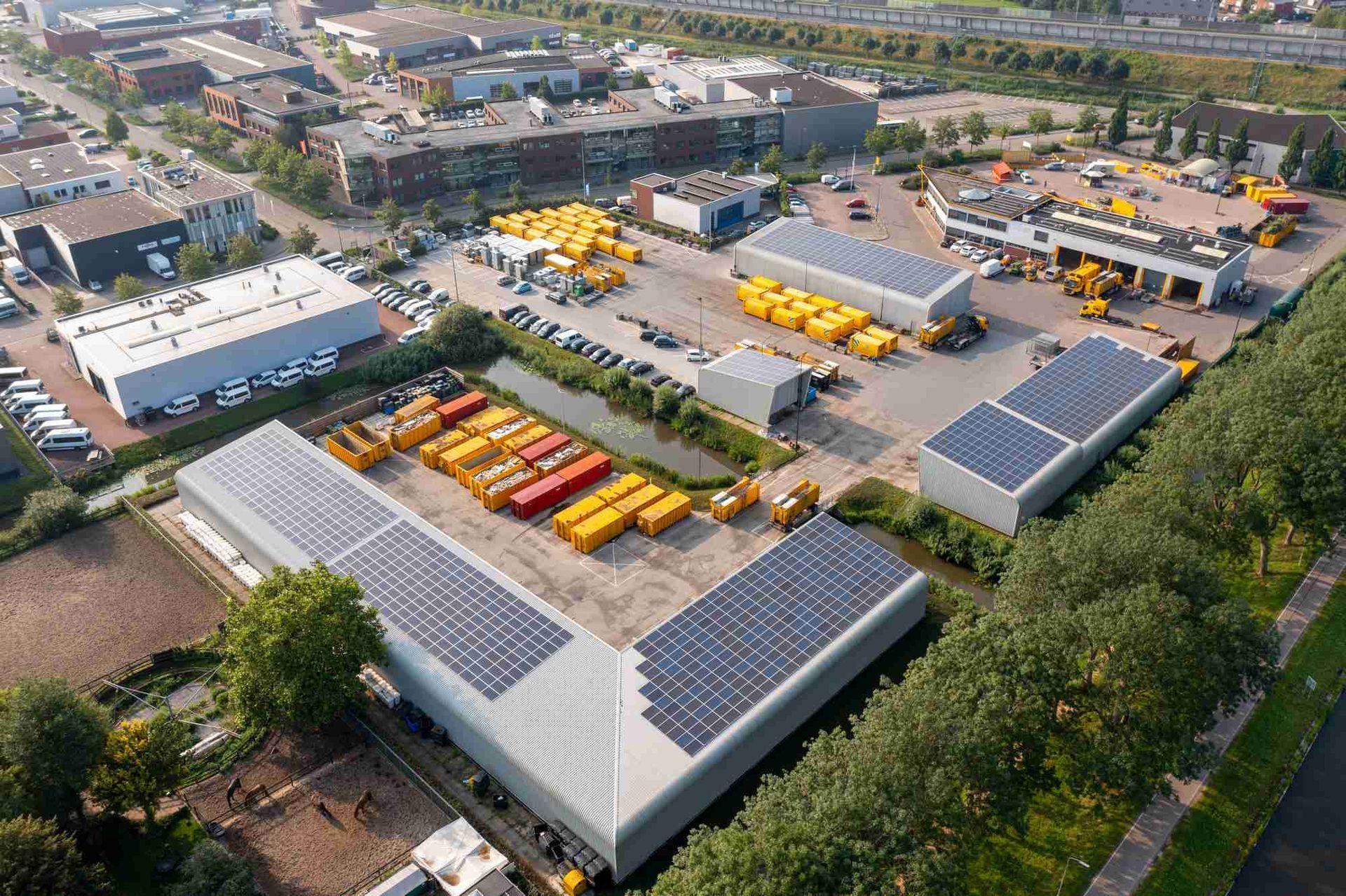 Een luchtfoto van een magazijn met zonnepanelen op het dak.