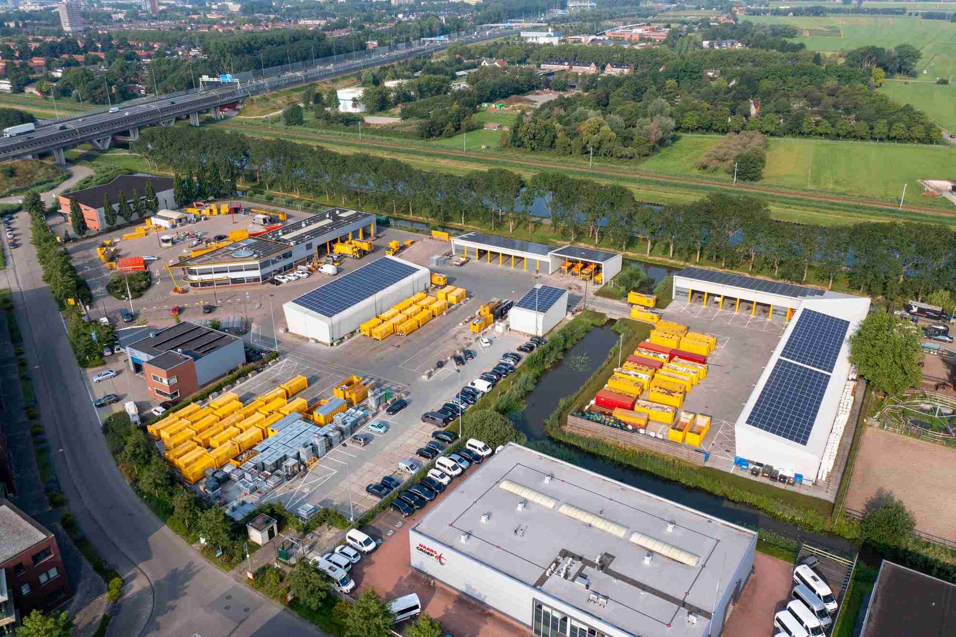 Een luchtfoto van een pakhuis vol met gele bussen.