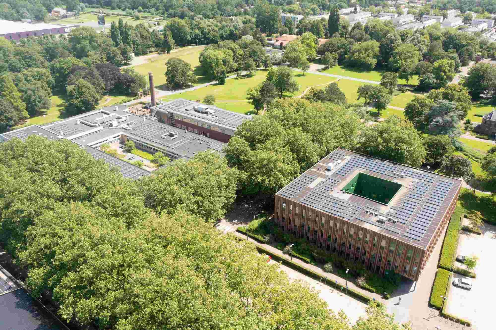 Een luchtfoto van een groot gebouw omgeven door bomen.