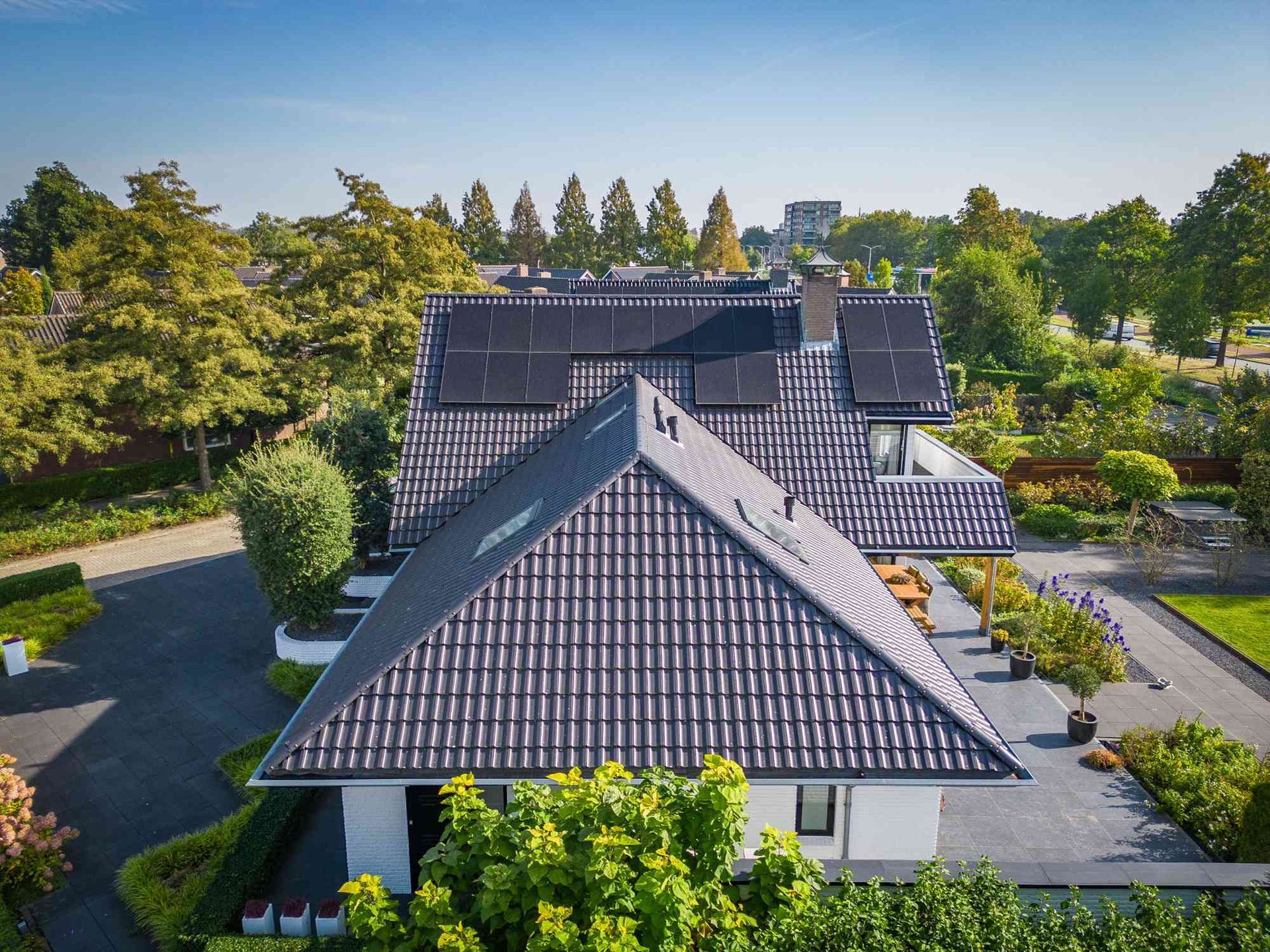 Een luchtfoto van een huis met zonnepanelen op het dak.