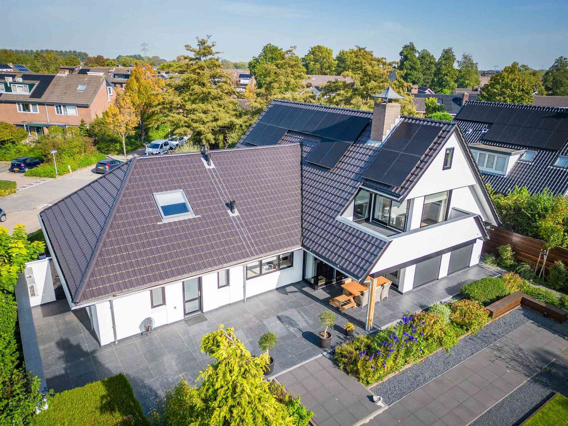 Een luchtfoto van een huis met zonnepanelen op het dak.