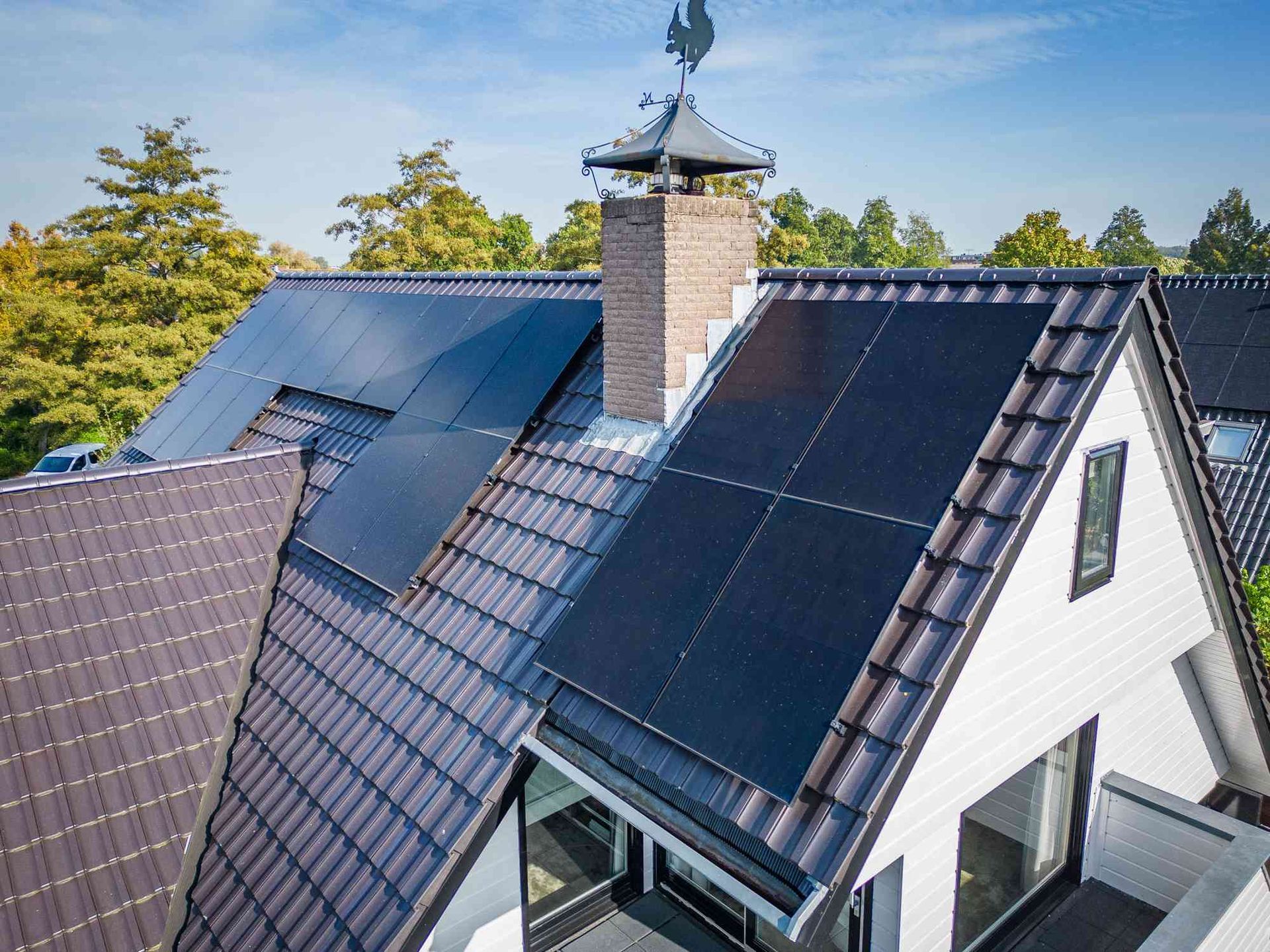 Een luchtfoto van een huis met zonnepanelen op het dak.