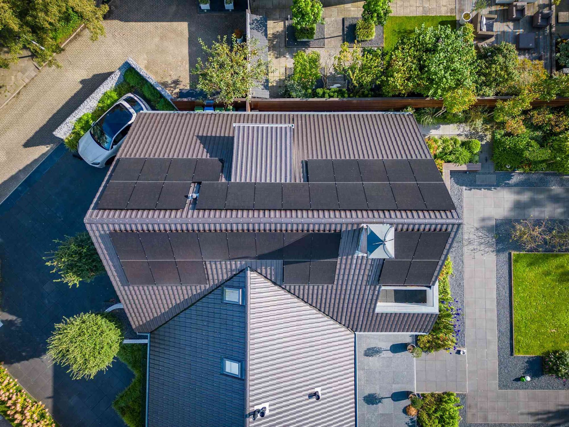 Een luchtfoto van een huis met zonnepanelen op het dak.