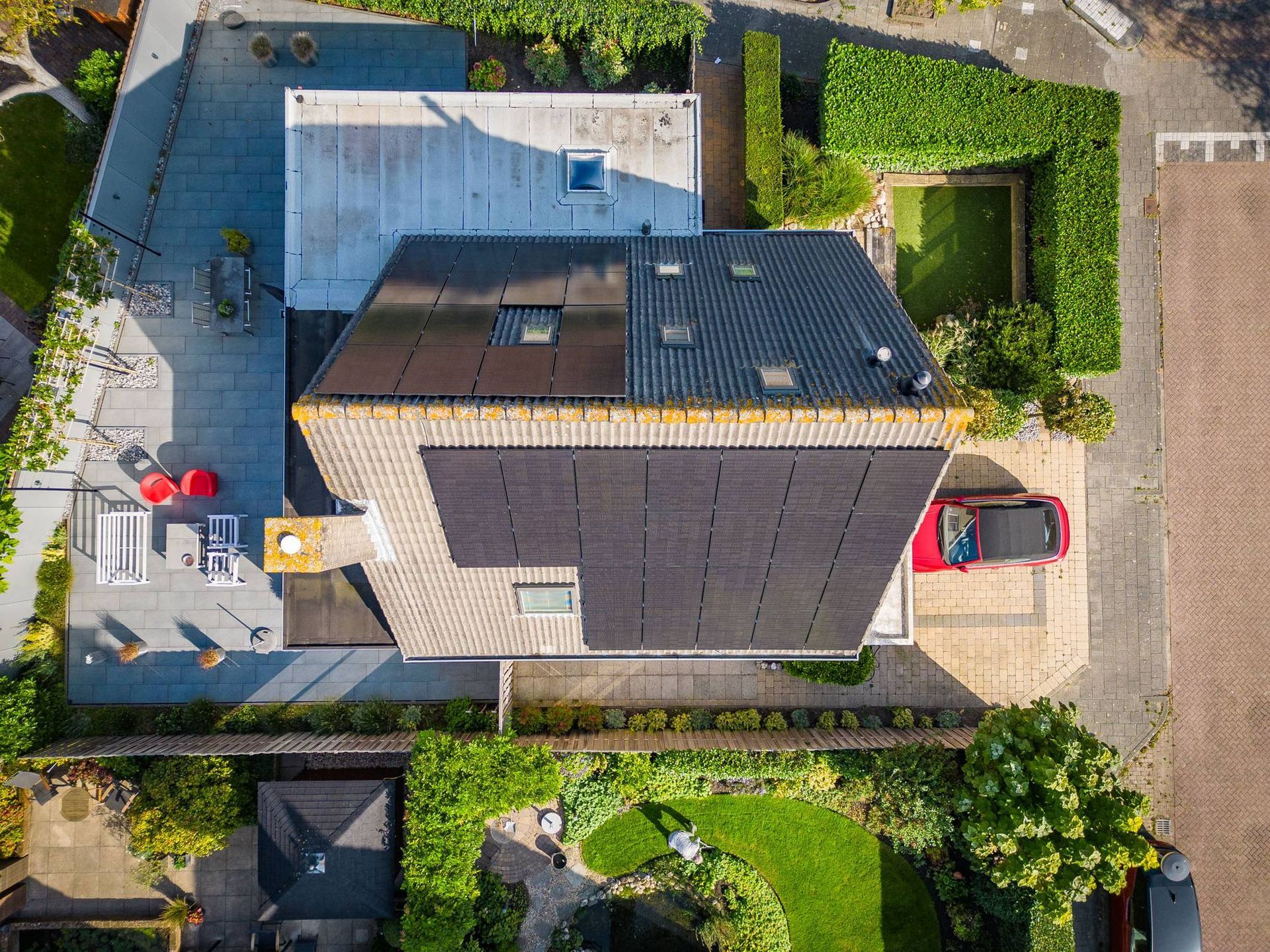 Een luchtfoto van een huis met zonnepanelen op het dak