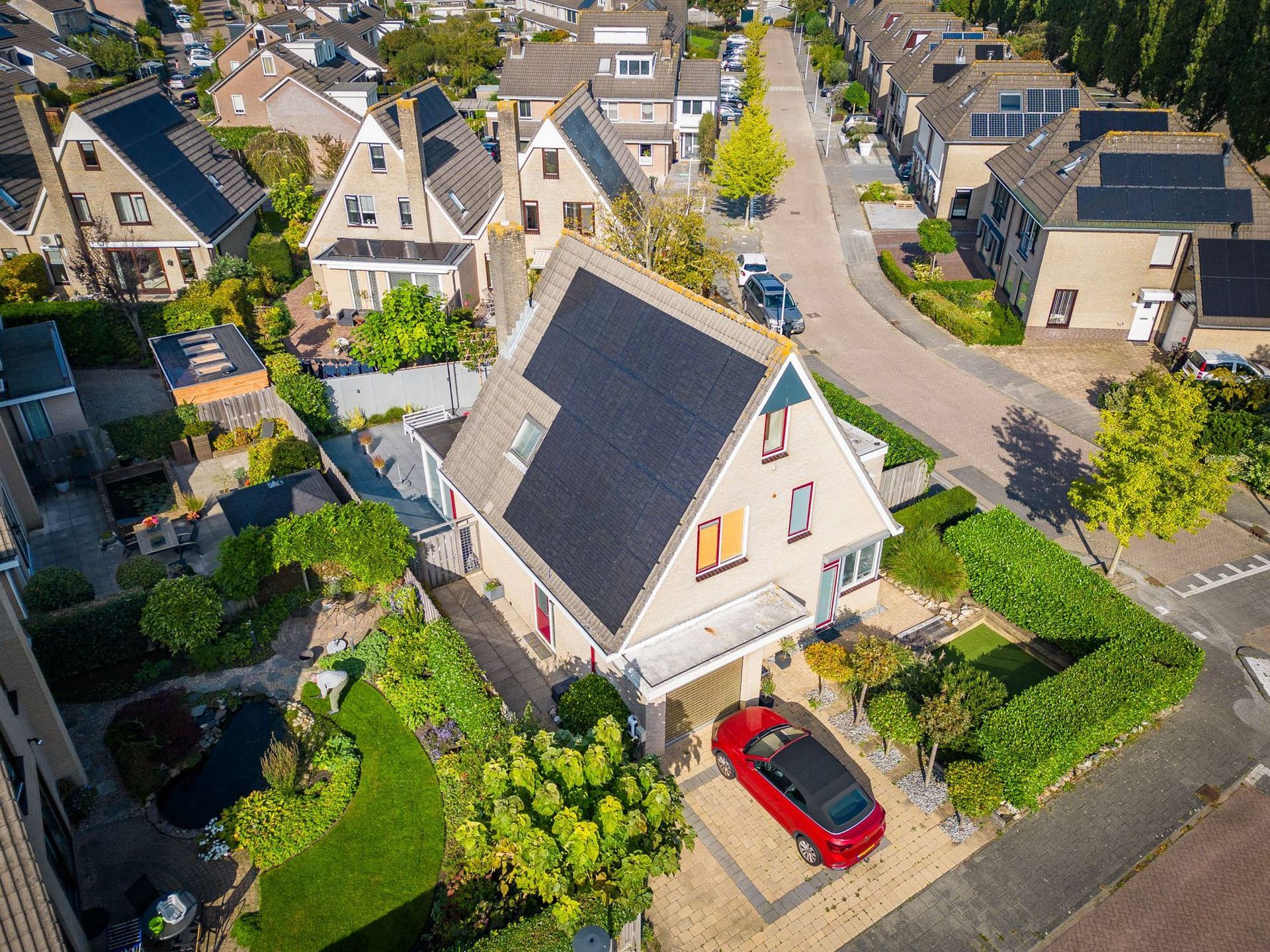 Een luchtfoto van een huis met zonnepanelen op het dak.